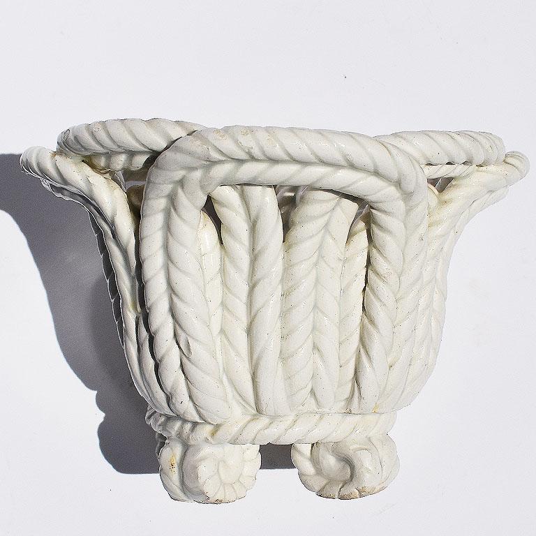 Récipient rond en céramique façonné dans un motif de corde ou de vannerie. Quatre pieds à volutes. Fabriqué en Espagne. 

Spécifications :
5.25