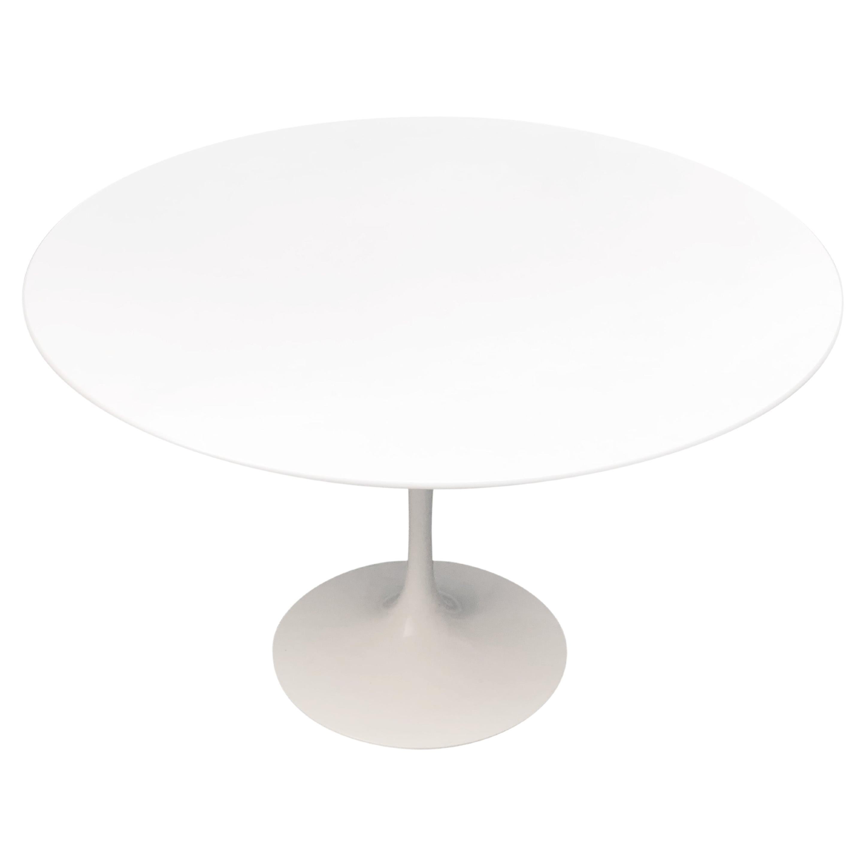 A authentic Eero Saarinen Tulip table in fair to good used condition. Cast aluminum pedestal powder coated in white Rilsan®. Table top appears to be the outdoor version in 'acrylic stone' and not from laminated wood or marble. There are minor
