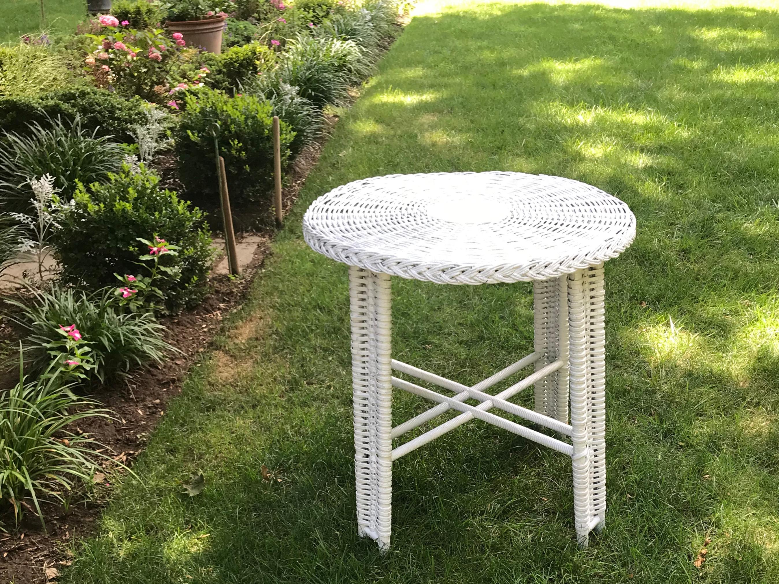 Round white wicker table antique white painted round wicker table on four interlocked webbed legs with spindle stretchers in original condition This is the original type of oft painted old wicker pieces found on many an American summer porch with