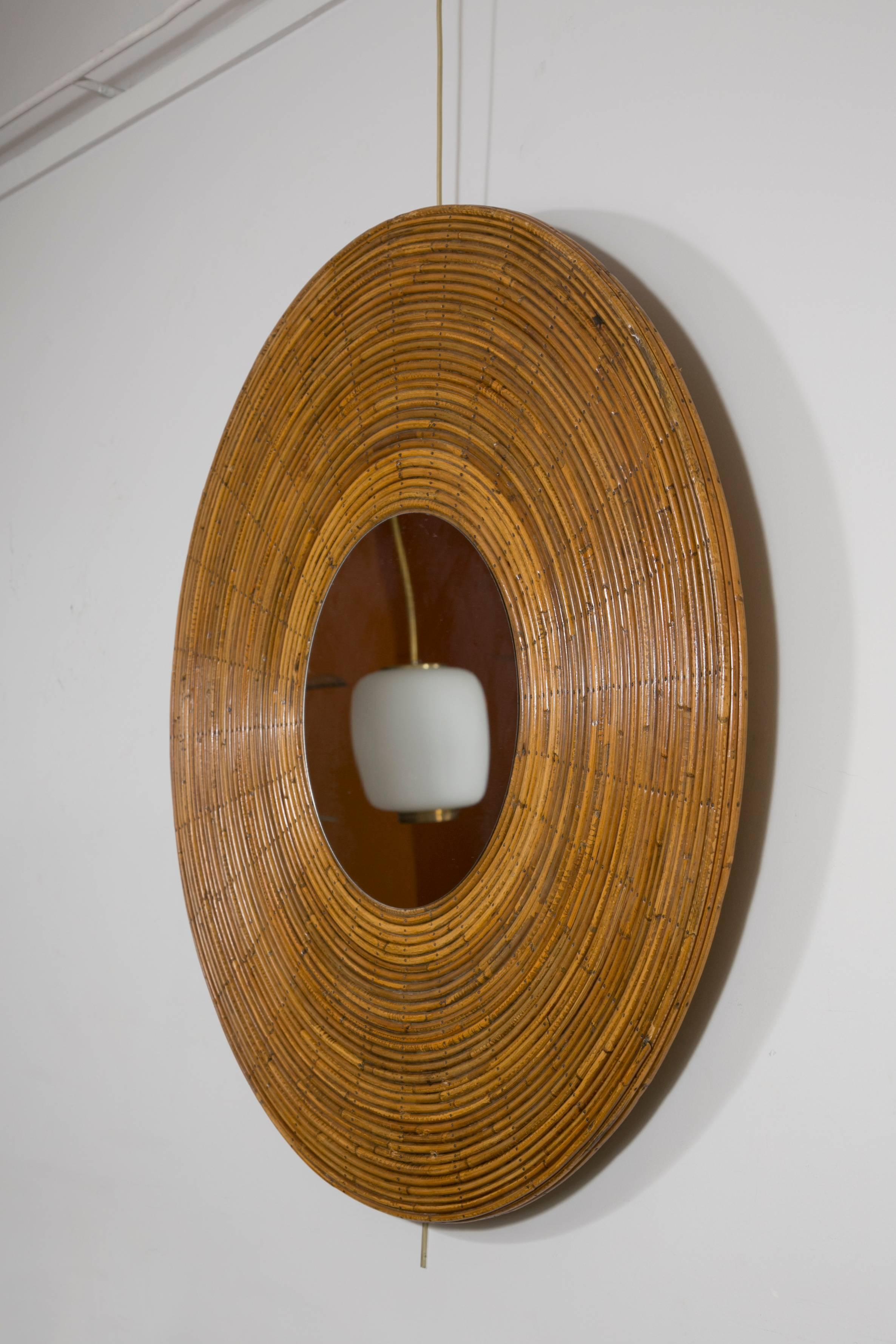 A round mirror with large wicker frame
France, circa 1965.

Measures: Diameter 100 cm
Depth 3 cm.