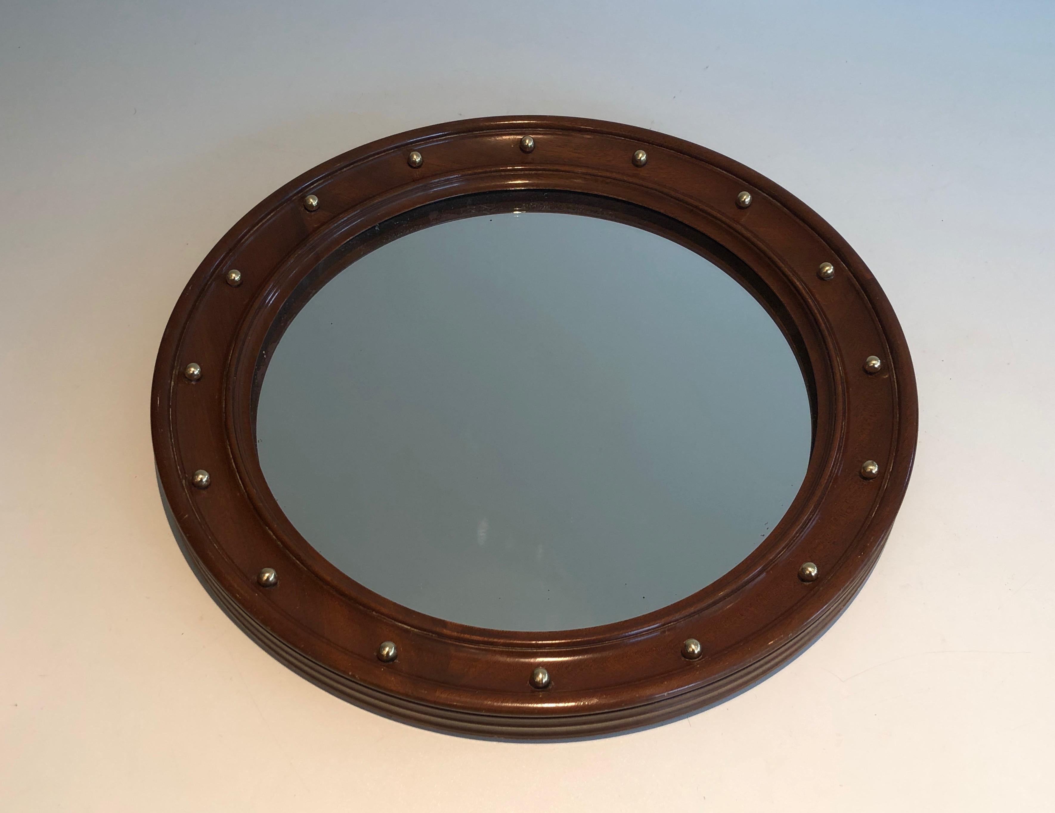 This round mirror is made of wood and brass. This is a French work. Circa 1950.