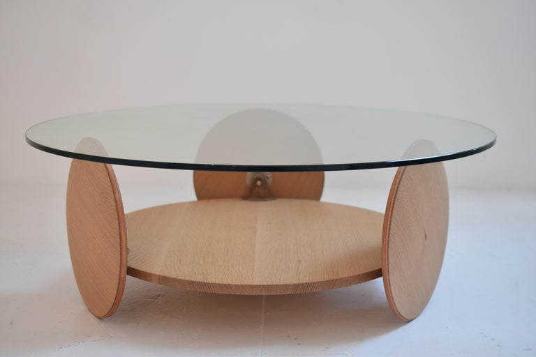 Revolution table

A machine pared down to its most simple parts, this coffee table with its five circular elements gracefully rotates. It features lathe-turned wooden wheels with leather tires and cast bronze hardware. The low slung wooden shelf