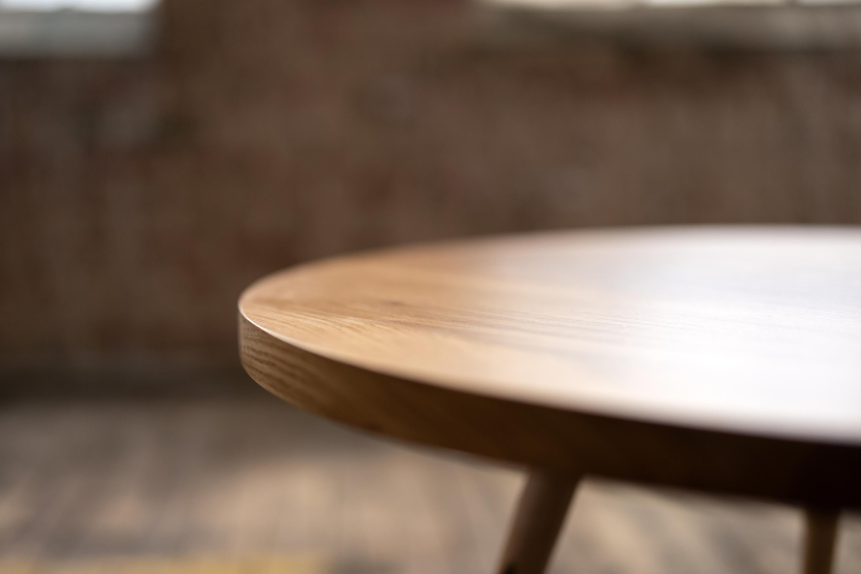The round Velma coffee table gives a nod of respect to Mid Century Modern inspired design and craft. The sleek maple legs are hand turned on the lathe. Discreet walnut details combine with the expressive grain of urban wood to present a clean and