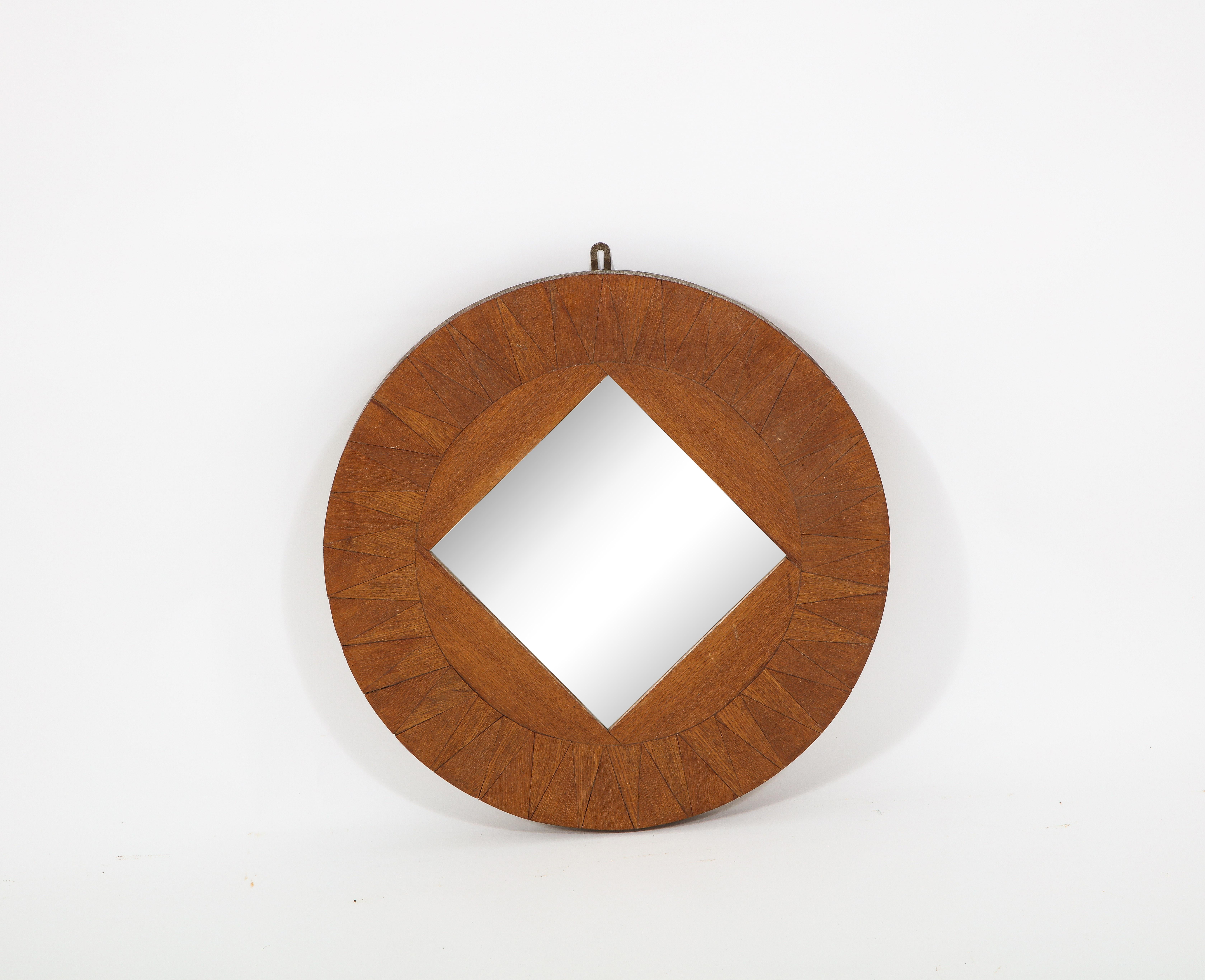 A round mirror in patterned veneer inlays with a square mirror insert.