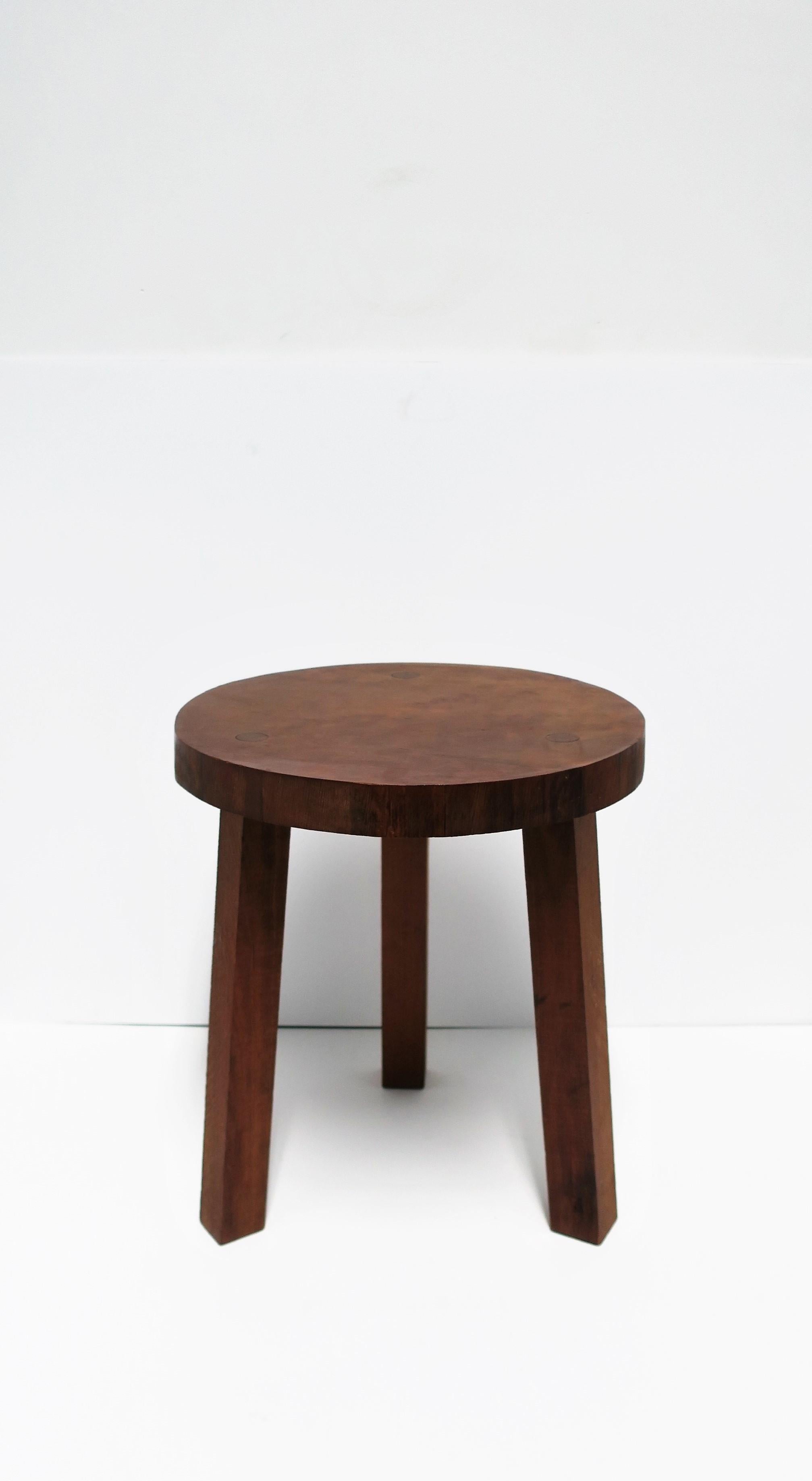A beautiful round wood stool or side table with tri-pod leg base, in the Brutalist style. Large wood screw detail on top/seat area as shown in images. Quality wood. Top seat wood thickness measures: 1.38