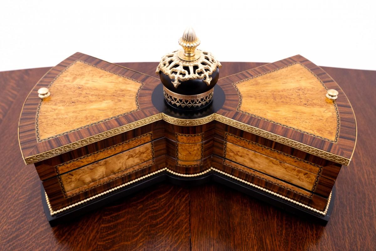 Wooden decorative jewelry box. Made of walnut wood with metal elements. The box has been renovated, lined with new, dark green fabric. The box has compartments for rings, jewelry.

Very good condition, renovated.

Origin: early 20th