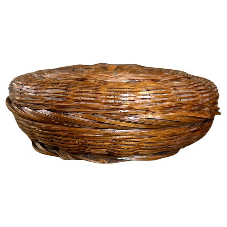 A round woven wicker bead basket with a lid. This petite wicker basket was forced from the Oklahoma estate of a woman who had a penchant for beading and Native American beadwork. Among her collection was an extensive amount of beadwork and