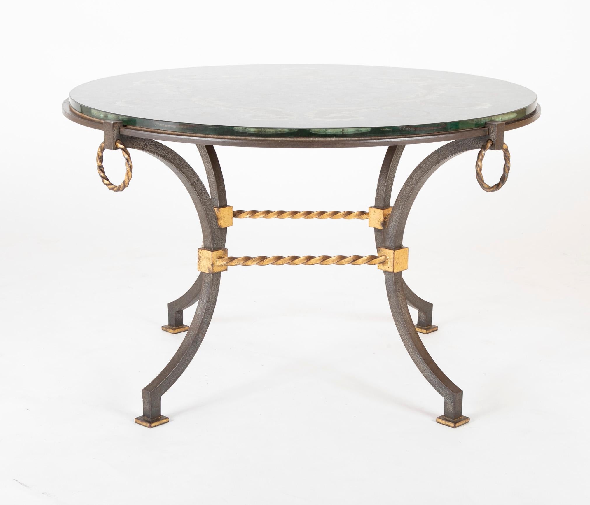A round wrought iron and églomisé coffee table, possibly French, circa 1930s.