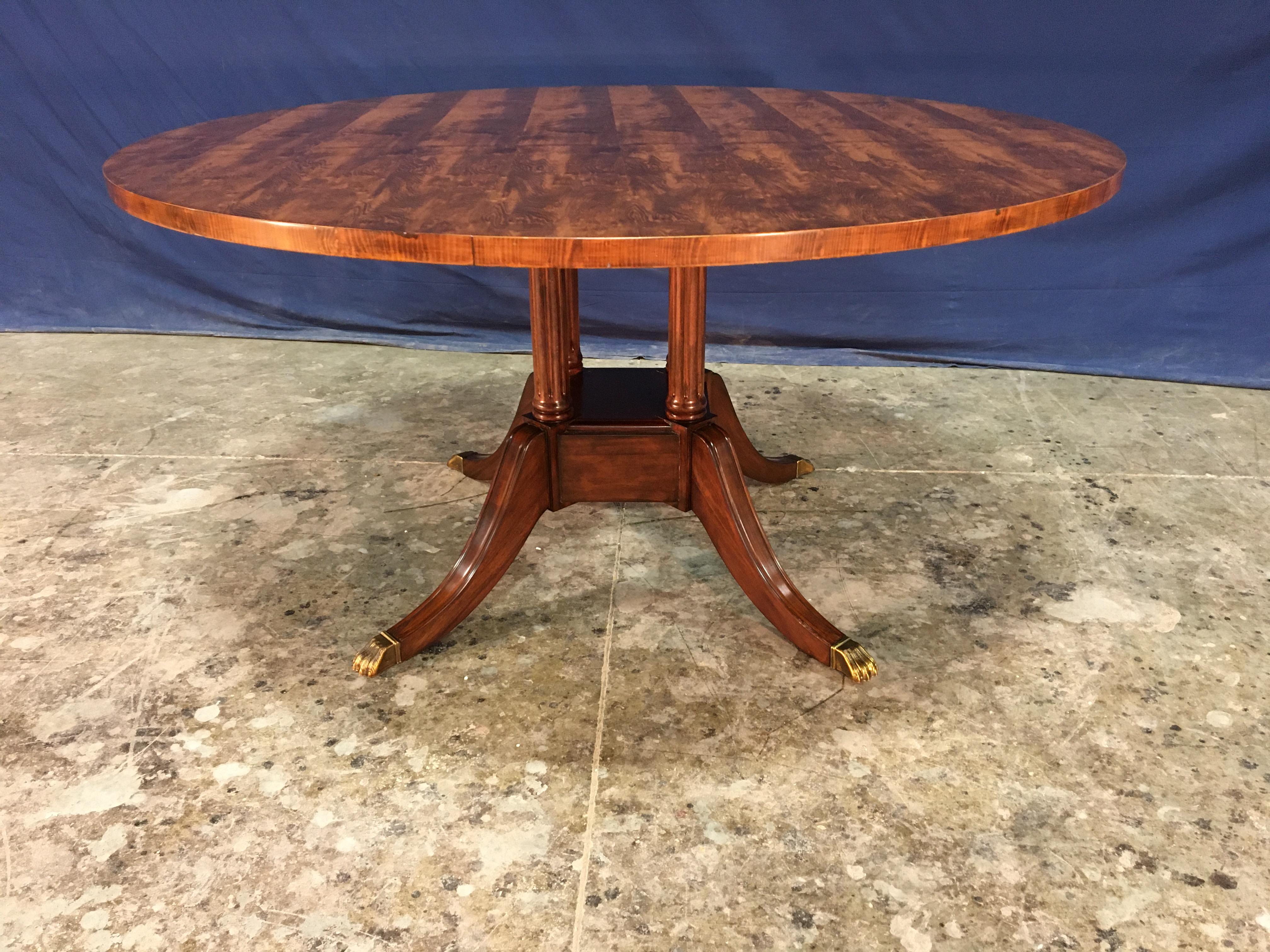 This is made-to-order round traditional Yew Wood top dining table made in the Leighton Hall shop. It features a field of slip-matched Yew Wood. The top has a hand rubbed and polished semigloss finish. The large birdcage pedestal has fluted legs