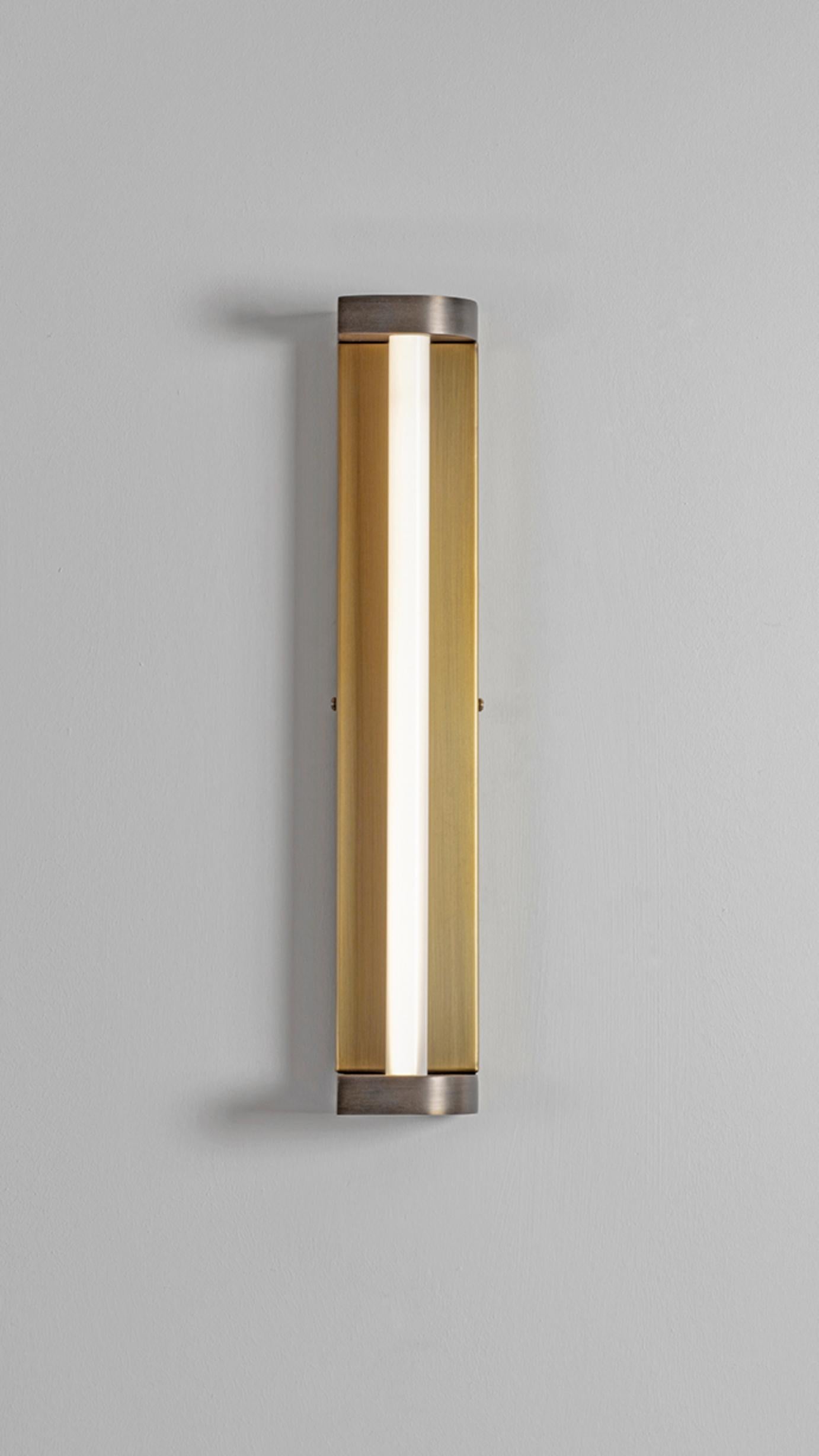 Rounded Corner Wall Light by Square in Circle
Dimensions: D 5 x W 7 x H 40 cm.
Materials:Brushed brass/ medium bronze/ opaque perspex
Other finishes available.

A tall, rectangular bathroom wall light with curved returns at top and bottom and an