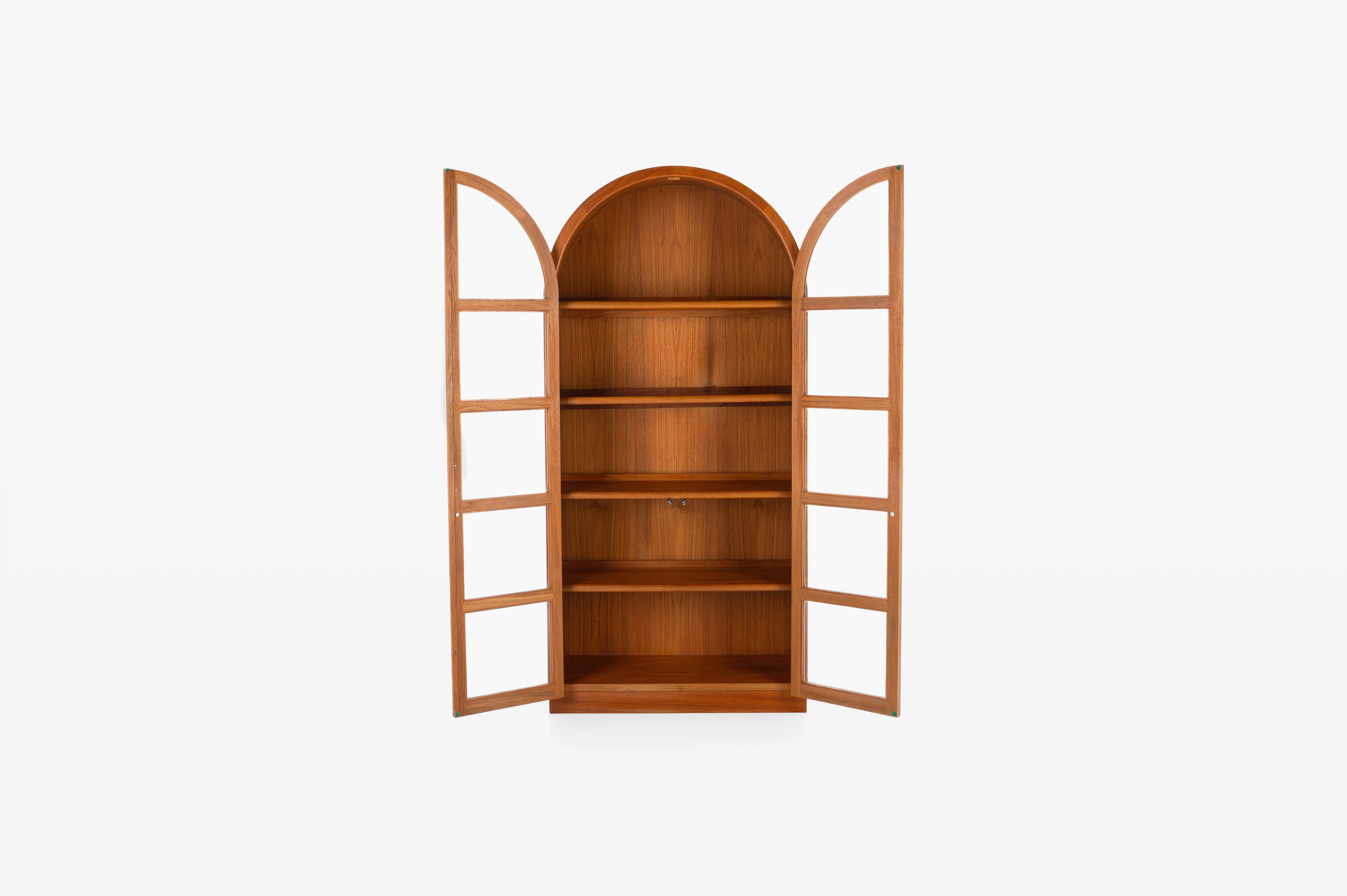 Impressive Danish vintage display cabinet in teak. The cabinet is rounded at the top, has two doors and five shelves and two cute handles. The cabinet has lighting inside and is in great condition.

Dimensions:
W: 90 cm
D: 45 cm
H: 188,5 cm