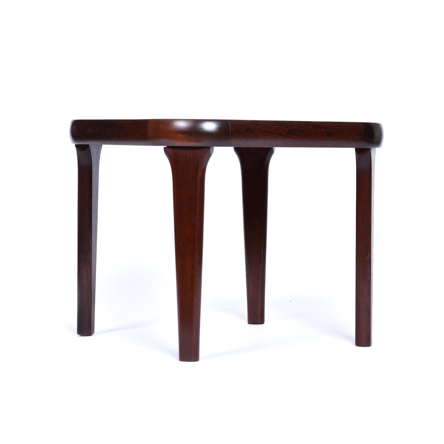 Vintage rounded square Danish Modern rosewood end table. The vintage side table has been professionally refinished, revealing the exquisite marbled wood grain. Rich swirls of dark and light reddish, dark and golden hues breathe a natural beauty into