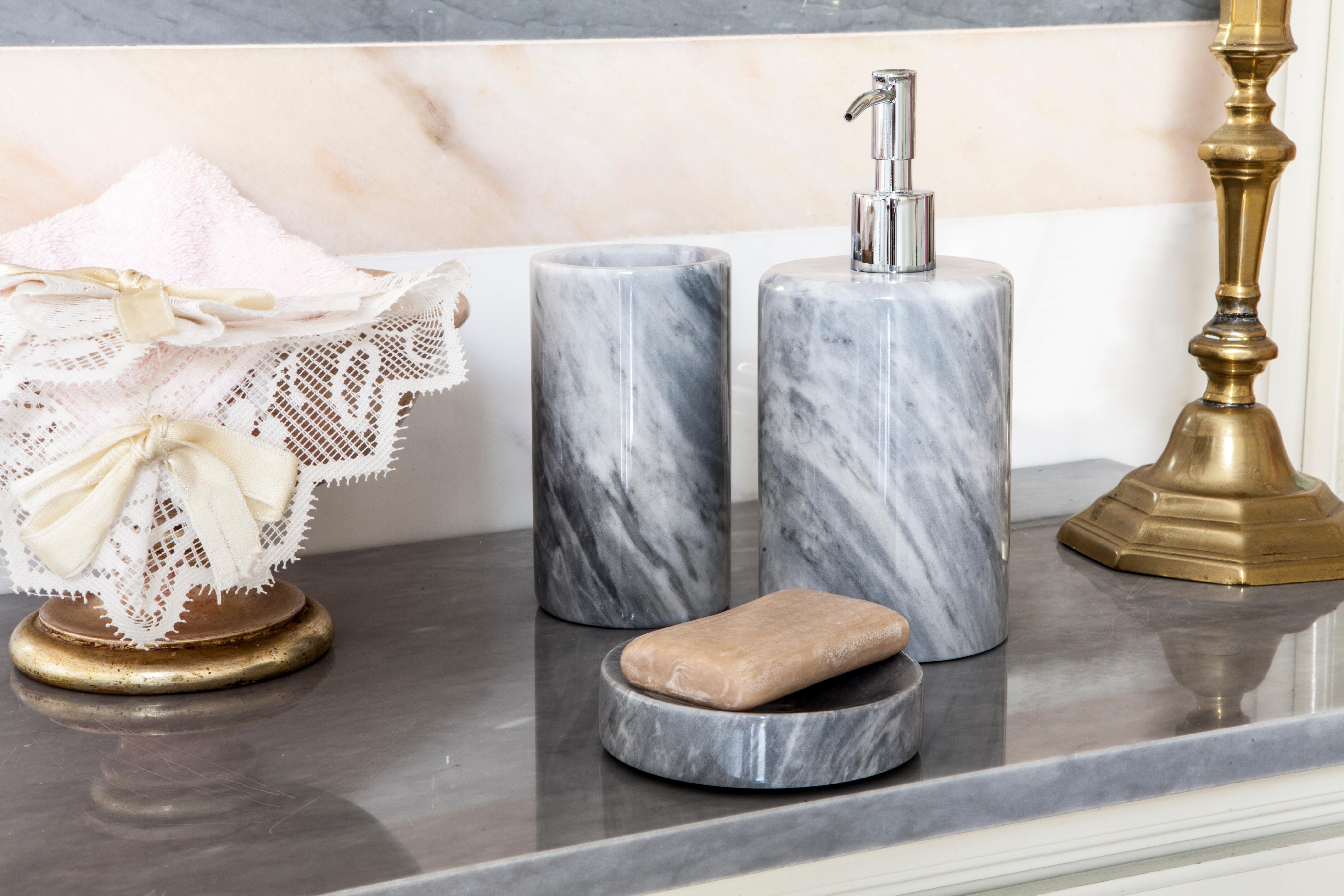 Ein abgerundetes Set für das Badezimmer aus grauem Bardiglio-Marmor, das Folgendes umfasst: Ein Seifenspender (Durchmesser 9 x 19,5 cm), ein Zahnbürstenhalter (Durchmesser 7 x 12 cm), eine Seifenschale (10 x 2 cm).
Jedes Stück ist in gewisser Weise