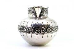 Rounded silver wine jug with exposed floral motifs, double handle and beaded rim