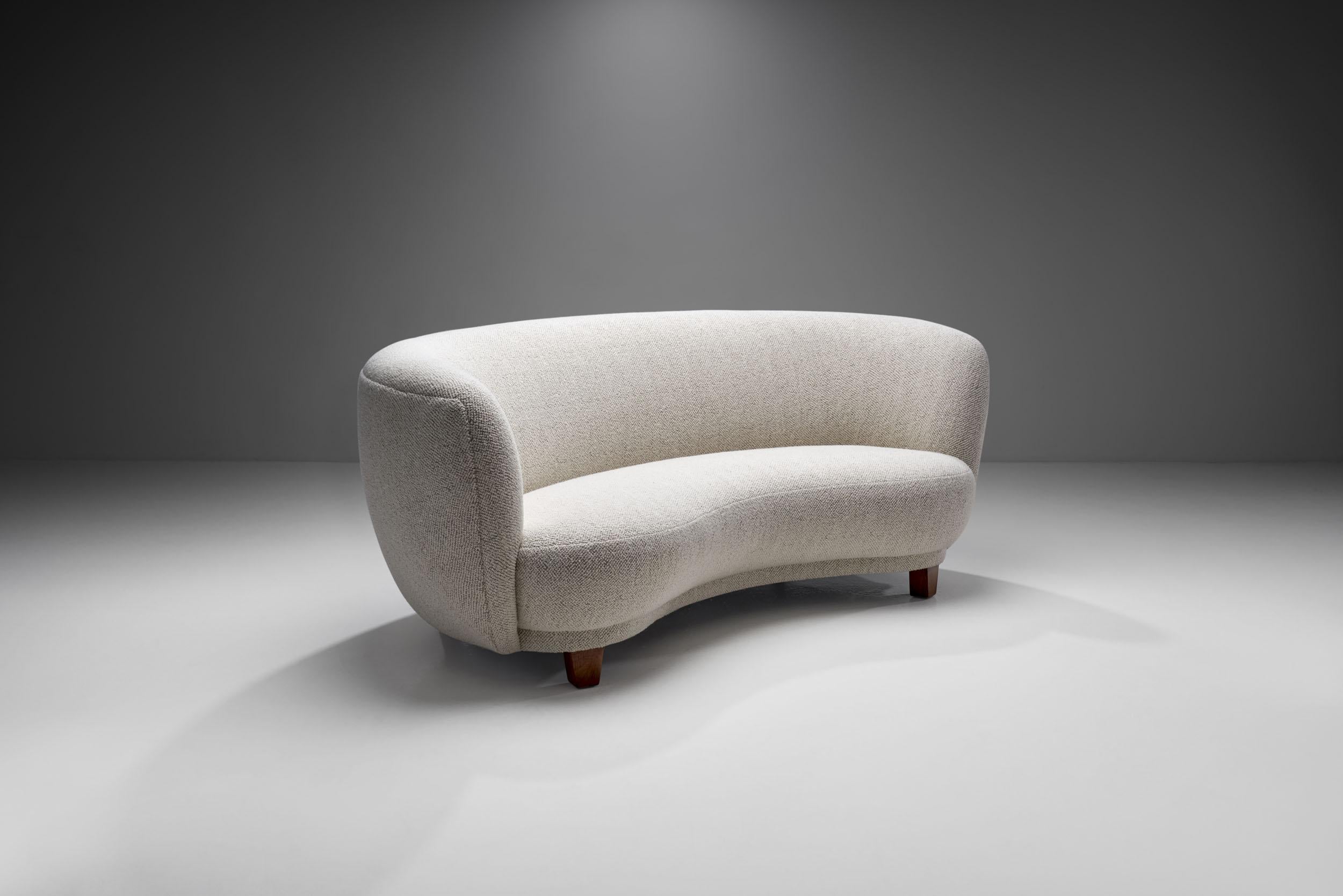 This sumptuous curved sofa features the recognisable touch of Danish Modernism: exquisite materials, craftsmanship, and an elegantly curved shape, because of which this type of sofa is often referred to as the “banana” or “boomerang”