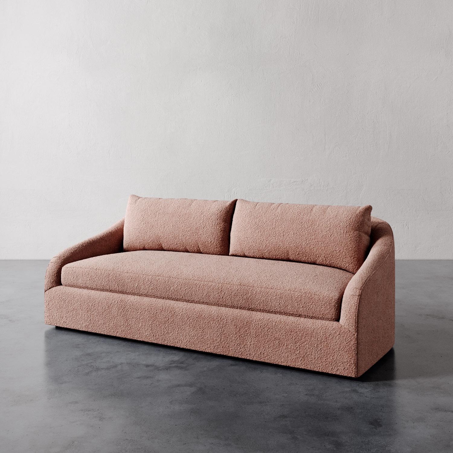 The Rousseau Sofa from Lemieux et Cie is a study in quiet elegance, its graceful lines and sculptural silhouette evoking the refined restraint of 1940s French design. The subtly sloped arms lend a soft curvature, recalling the enveloping