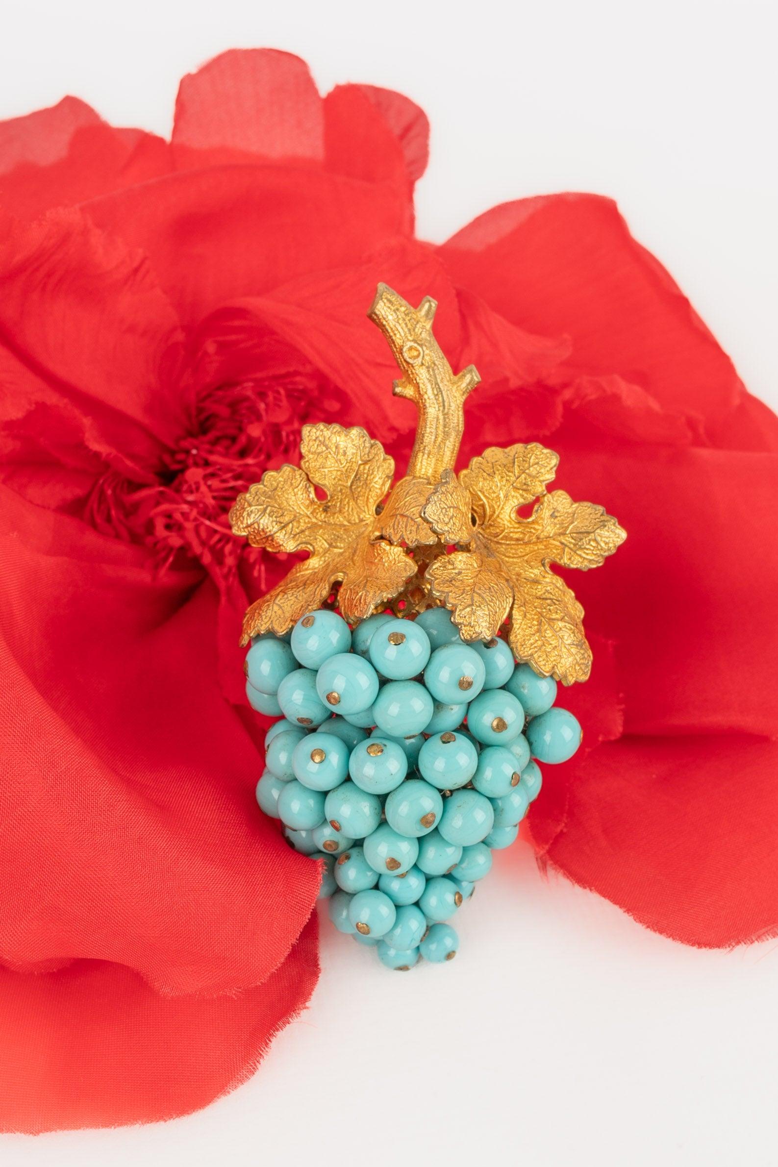 Rousselet - (Fabricado en Francia) Broche de metal dorado con pequeñas perlas de pasta de vidrio de color turquesa que representan un racimo de uvas. Joyas no firmadas - obra del taller Rousselet.

Más información:
Estado: Muy buen