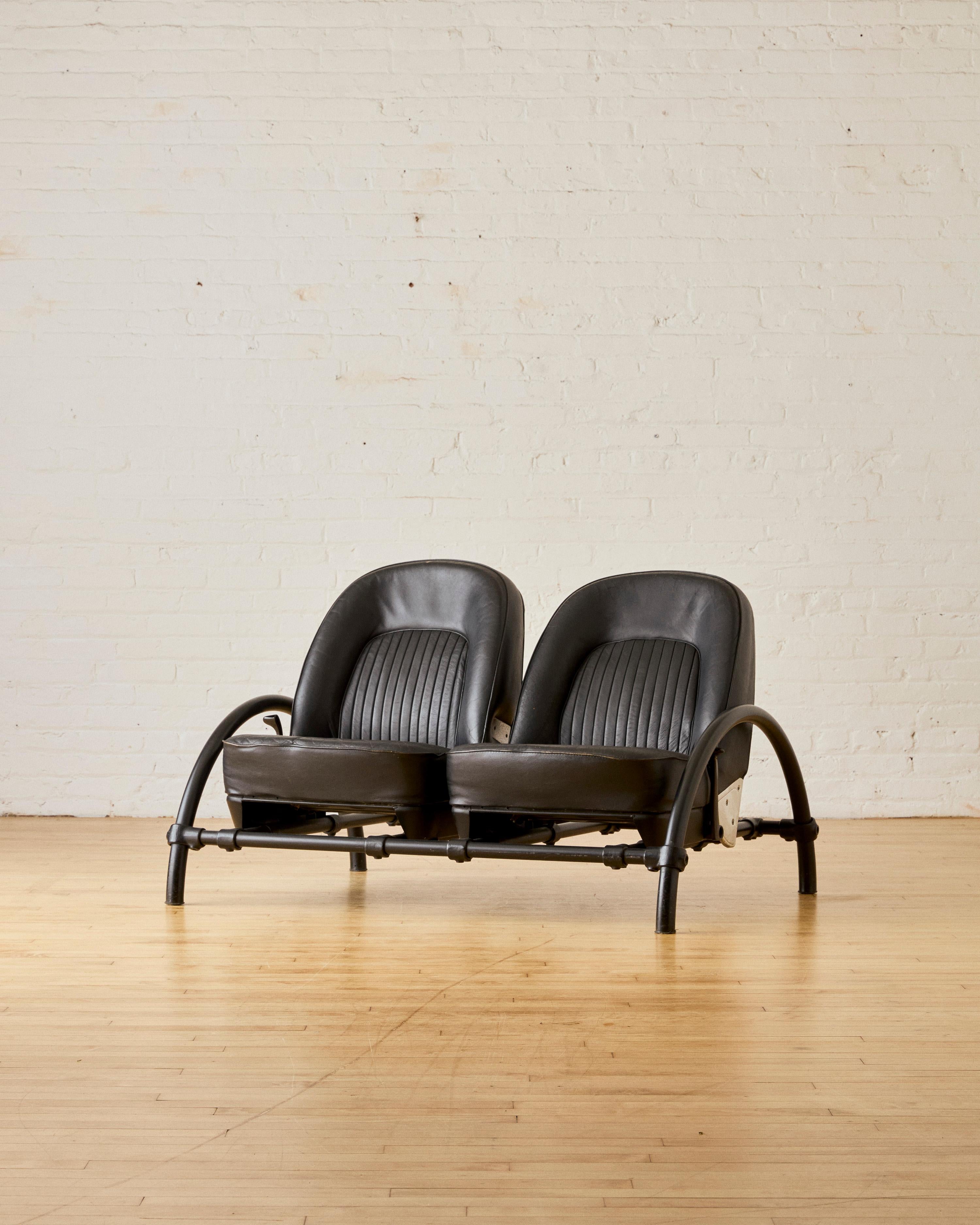'Rover' two seat sofa by Ron Arad for One Off Ltd, constructed in a black lacquered aluminum horse shoe frame, and reclining seats in black leather. Was featured in the Museum of Modern Art New York (MoMA)

