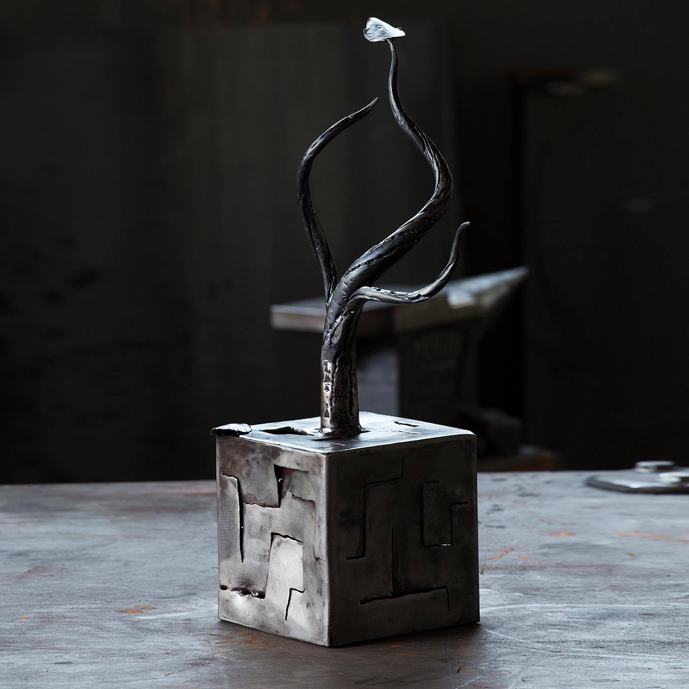Exuding a sweet, serene melancholy and dynamic movement, a symbol of the coming of a new season, this sculpture features a sinuous, bare tree resting on a cubic base carved with geometric lines. A sublime showcase of craftsmanship, it is completed