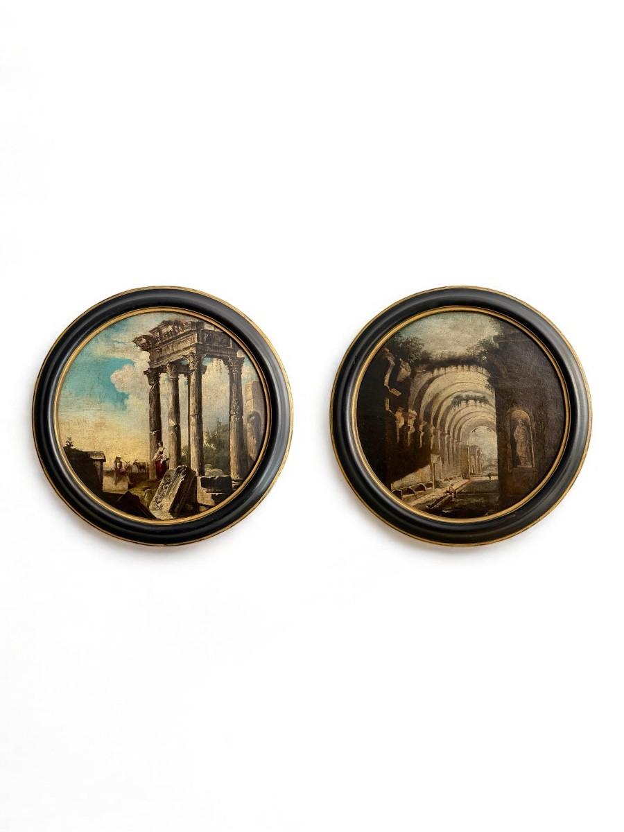 Dipinto 1: il primo dipinto rappresenta una scena immaginaria di antiche rovine, dominata da colonne corinzie in parte crollate, che evocano un tempio romano. Ai loro piedi, figure umane in costume del XVII sec. animano la composizione, incarnando