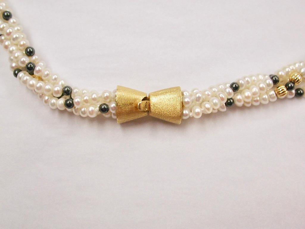  Row of Twisted White Multi-Bouton Shaped Cultered Pearls,18ct bow shaped Gold Snap.
19 inches long interspersed with round black cultered pearls and golden ribbed balls.
Unworn ex-jewellers stock.