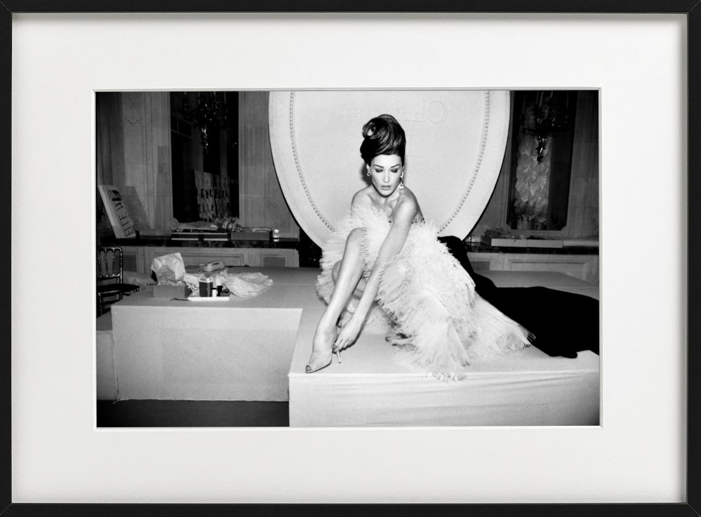 Carla Bruni in einem eleganten Kleid, wie sie sich hinsetzt und ihren Look zurechtrückt, fotografiert von Roxanne Lowit.

Alle Drucke sind in limitierter Auflage erhältlich. Erhältlich in mehreren Größen. Hochwertige Einrahmung auf Anfrage.

Alle