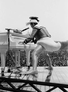 Elton John - the superstar on stage in a duck costume and playing piano
