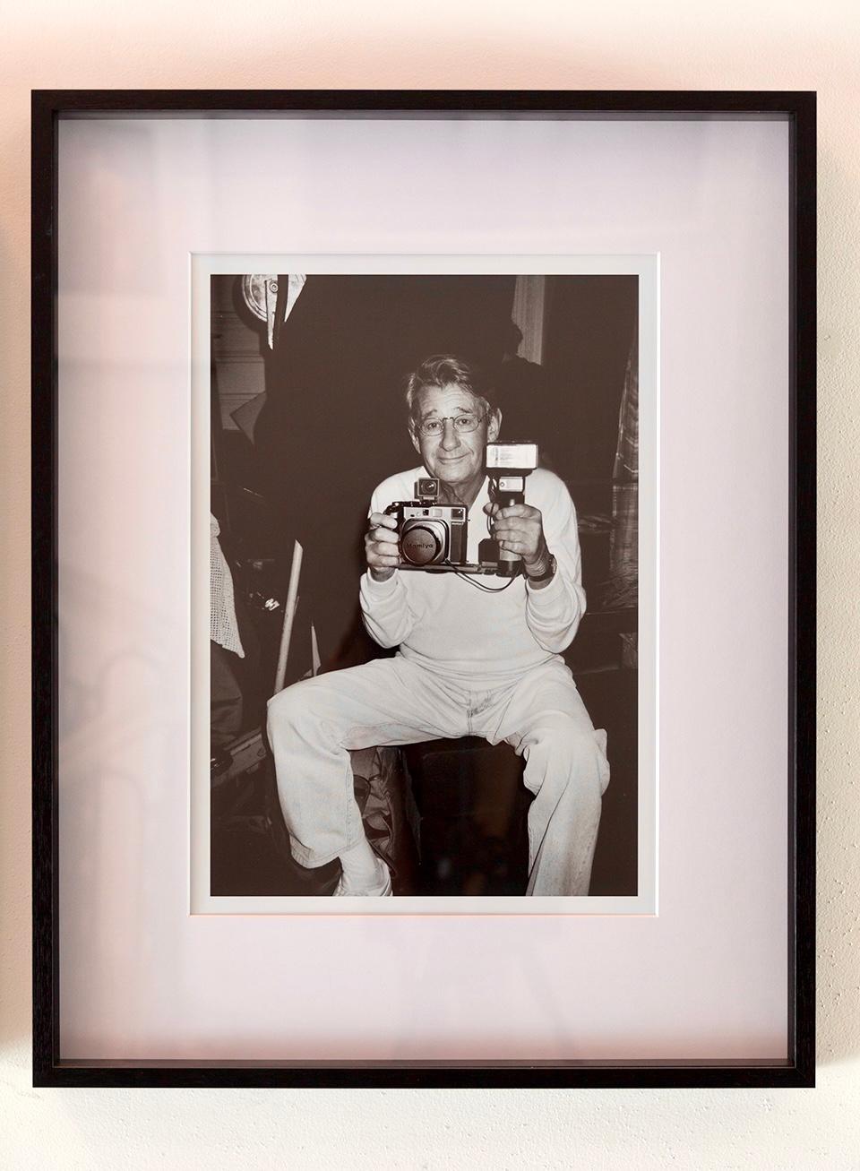 Helmut Newton, Paris - célèbre photographe tenant un appareil photo en b&w - Contemporain Photograph par Roxanne Lowit