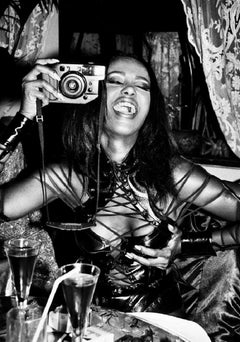 Iman, Paris - black-and-white portrait of model Iman in corsage with camera 