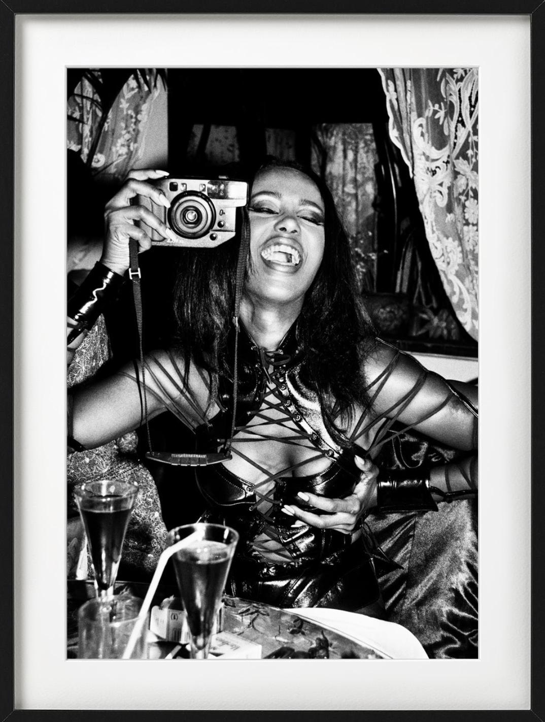 Iman, Paris - black-and-white portrait of model Iman in corsage with camera  - Photograph by Roxanne Lowit