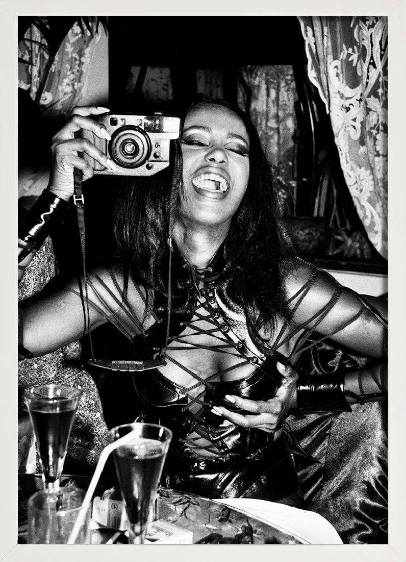Iman, Paris - black-and-white portrait of model Iman in corsage with camera  - Black Portrait Photograph by Roxanne Lowit