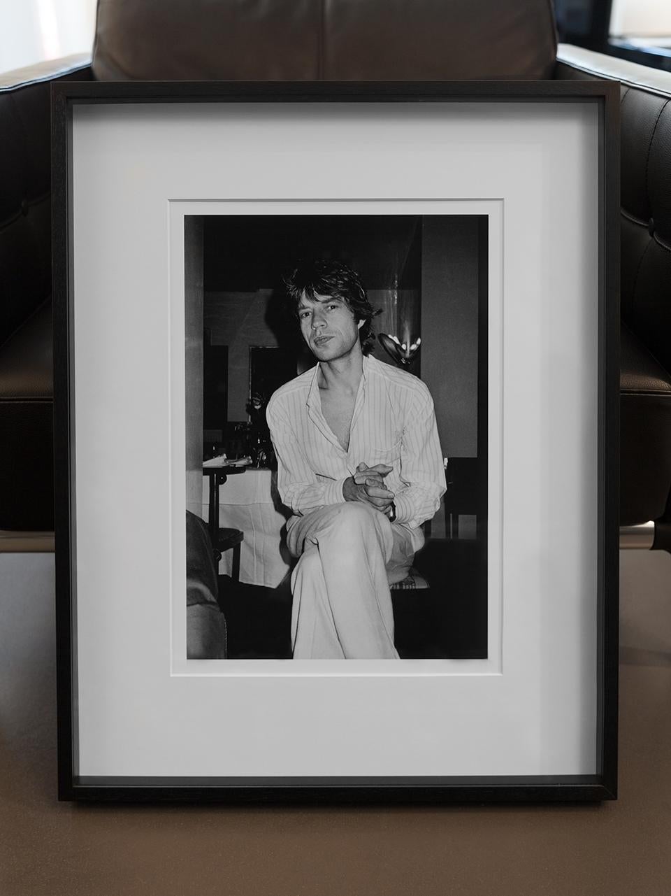 Mick Jagger Pleased, NYC the rockstar sitting in a pyjama on chair in hotelroom - Photograph by Roxanne Lowit