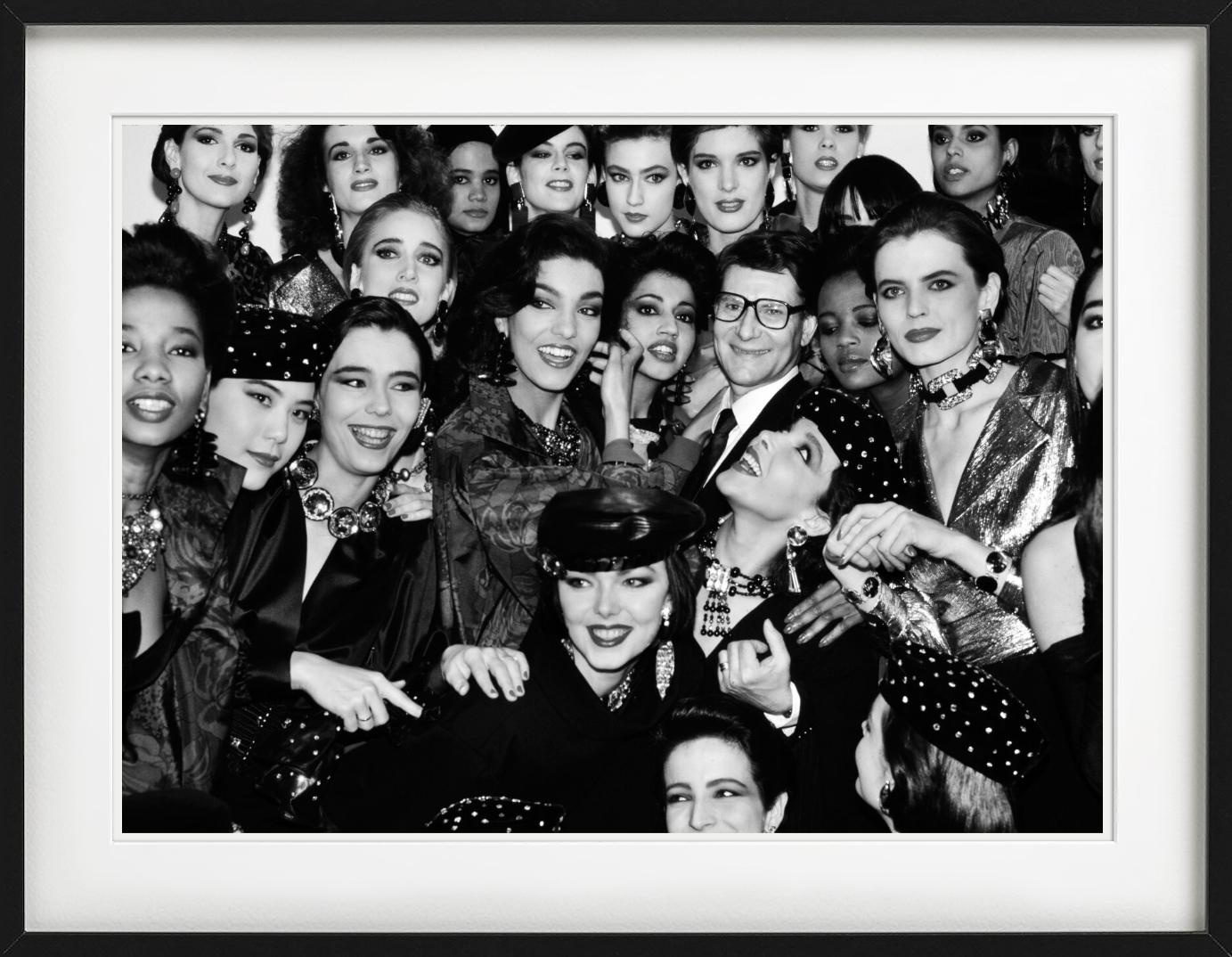 Yves Saint Laurent zwischen seinen Models nach der Modenschau, fotografiert von Roxanne Lowit im Jahr 1985.

Alle Drucke sind in limitierter Auflage erhältlich. Erhältlich in mehreren Größen. Hochwertige Einrahmung auf Anfrage.

Alle Drucke werden