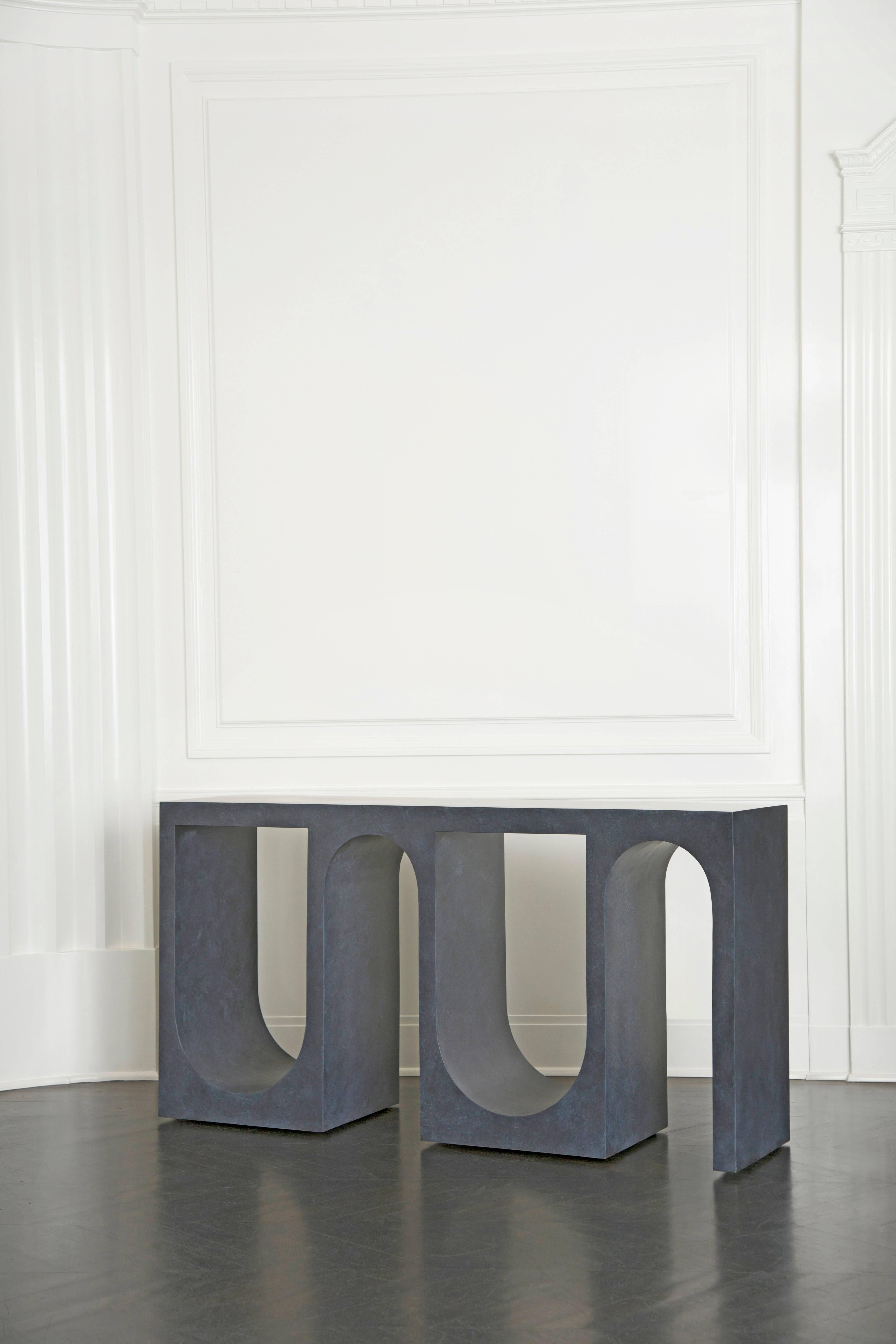 Cast in solid resin and featuring a hand-trowelled plaster finish, the Roxbury console possesses a graphic silhouette. Alternating arches form the shape of this unique console creating a beautiful modulation of geometry and color in space. Available