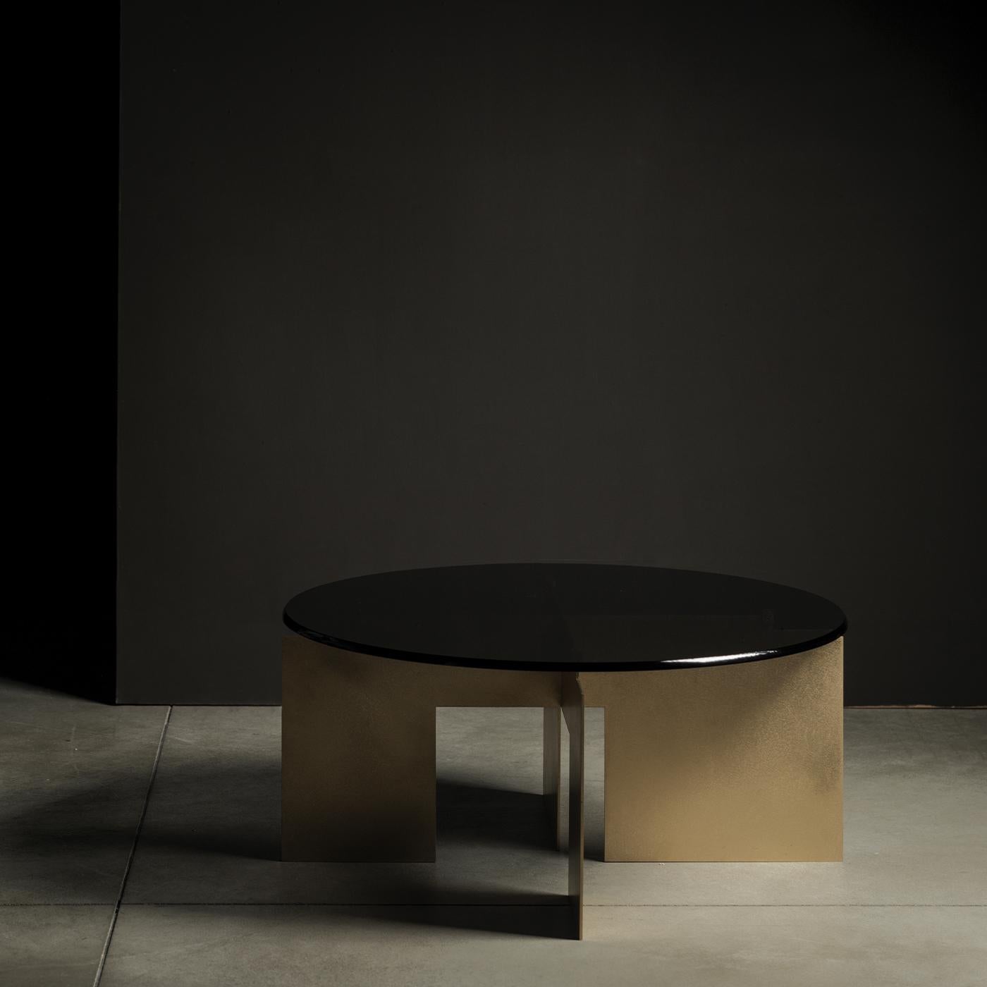 This striking coffee table features a brushed brass base that stands in contrast to its tinted, tempered glass top, creating a minimalist, essential style that is also highly original and unique. Designed by Filippo Montaino for the Chelini Firenze