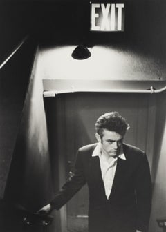 James Dean Beneath Exit Sign - black and white photograph by Roy Schatt