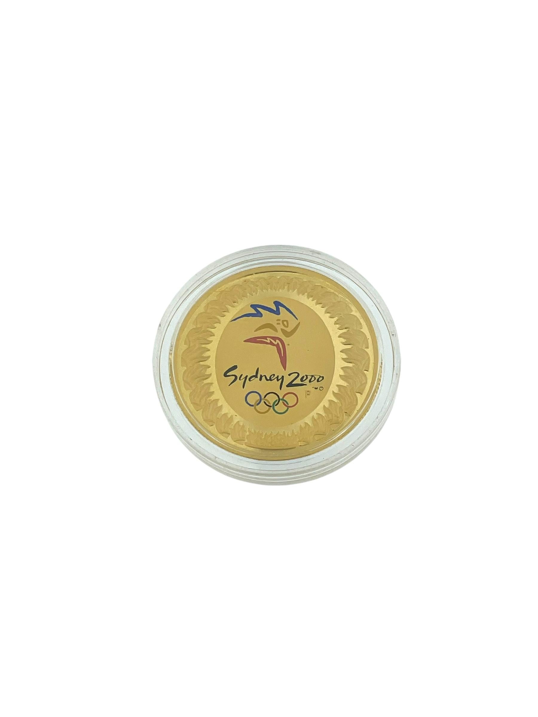 La **Royal Australian Olympic 24 Karat Gold Coin** conmemora los **Juegos Olímpicos de Sydney 2000**, uno de los momentos más emblemáticos de la historia deportiva de Australia. Acuñada en **oro puro de 24 quilates**, esta moneda encarna la