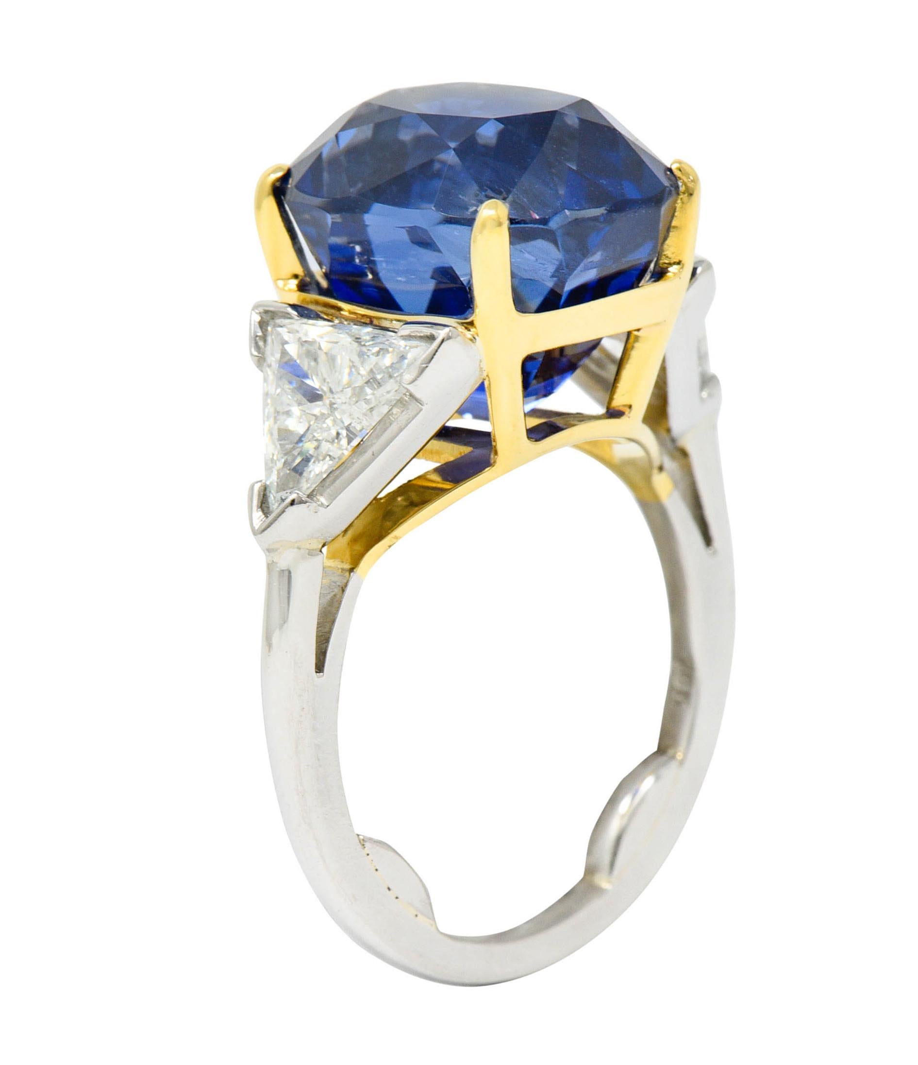 Centering an oval brilliant cut Ceylon sapphire weighing 20.06 carats

Deeply royal blue in color with no indications of heat - Sri Lankan in origin

Basket set in 18 karat gold and flanked by two trillion cut diamonds - V prong set in