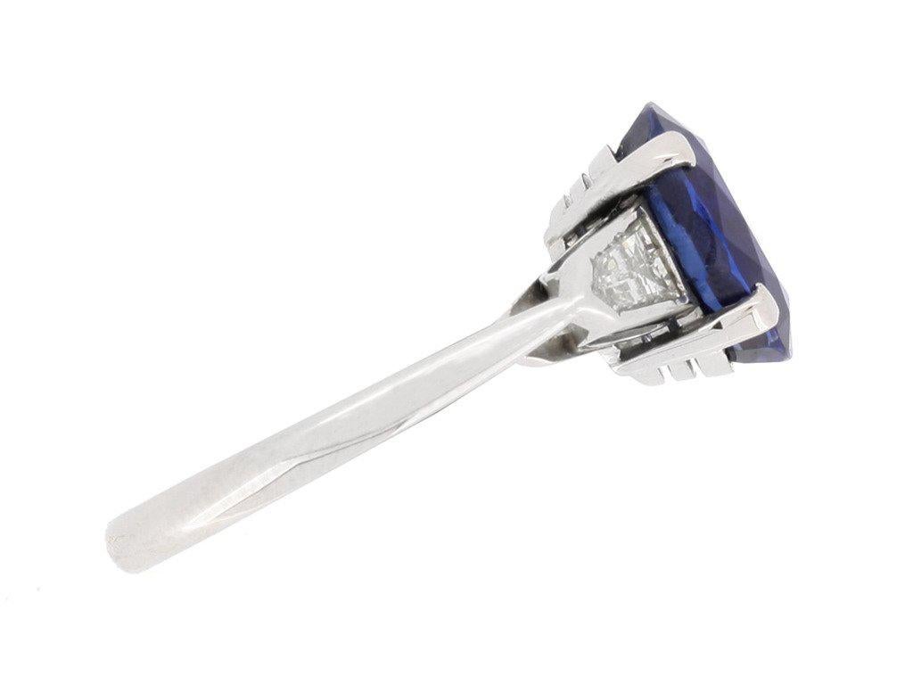 Royal Blue Burmese sapphire and diamond ring. Centrally set with an oval old cut natural unenhanced Royal Blue Burmese sapphire in an open back claw setting with an approximate weight of 3.75 carats, flanked by two arrow shape tapered baguette cut