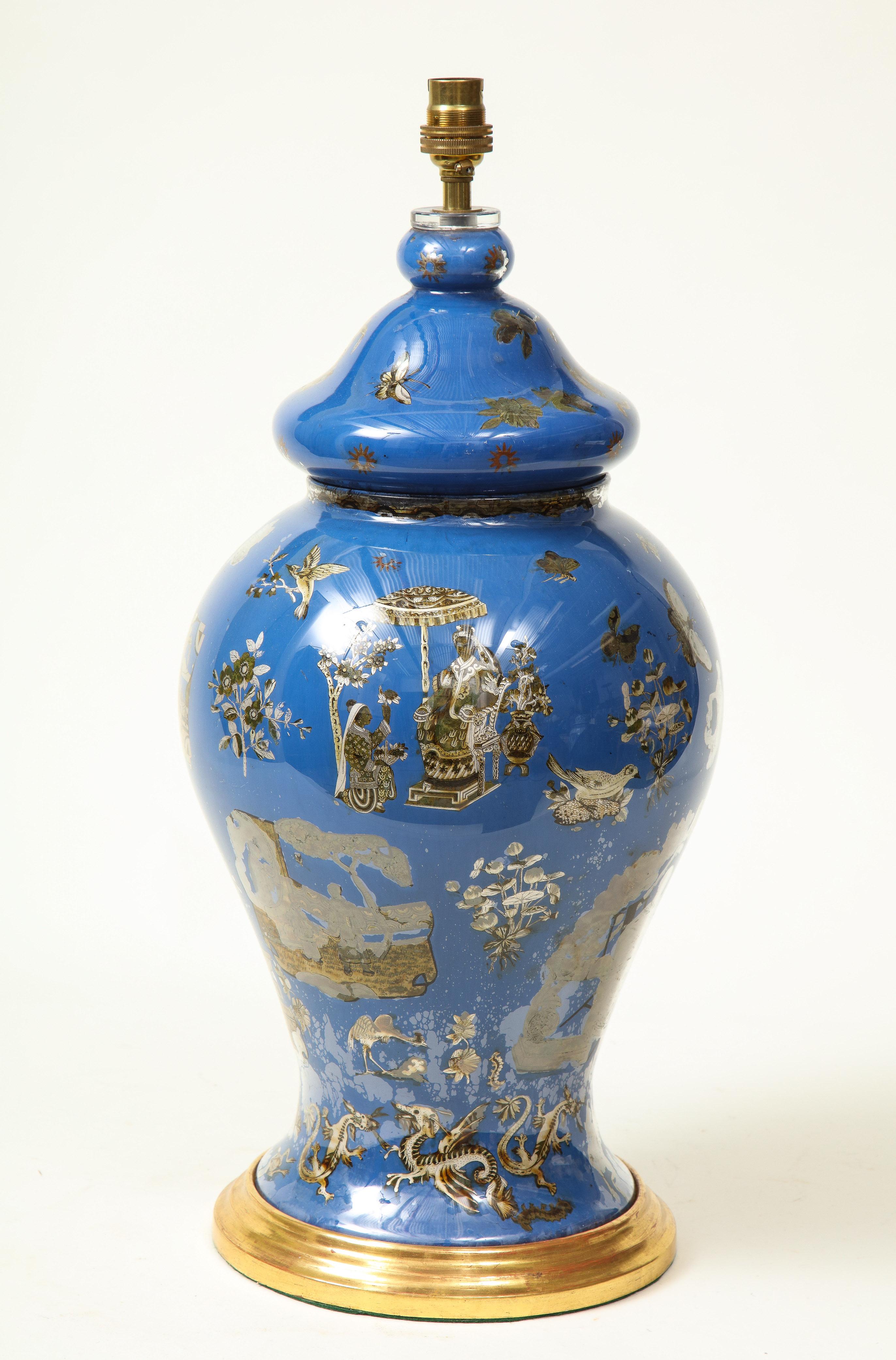 With lidded glass vase of baluster from decorated with sepia-toned Chinese court figures, butterflies, dragons, floral sprays, and more; on a turned giltwood base.

Provenance: From the Collection of Mario Buatta, New York, NY