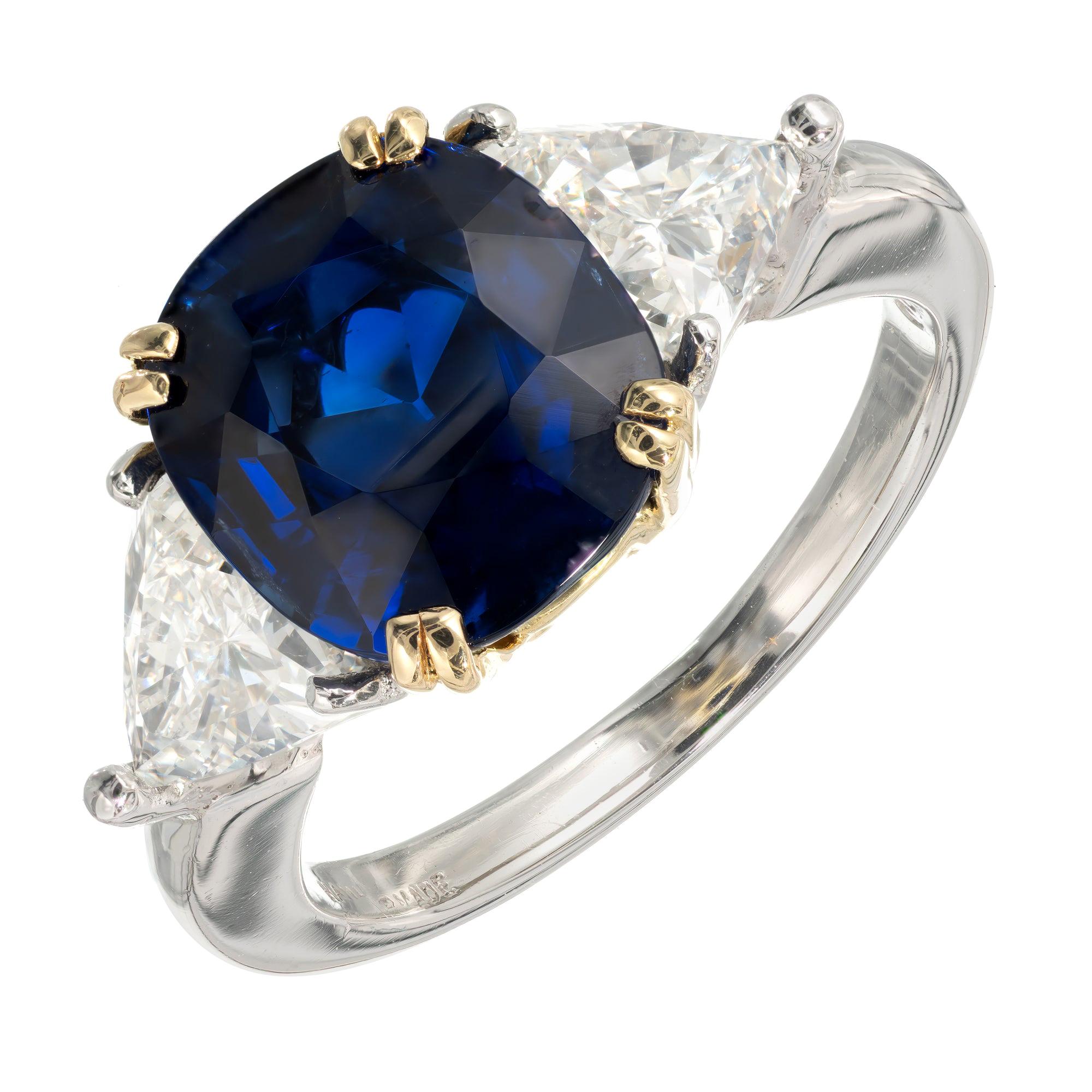 Anillo de compromiso de oro y platino con zafiro azul real en cojín y diamante