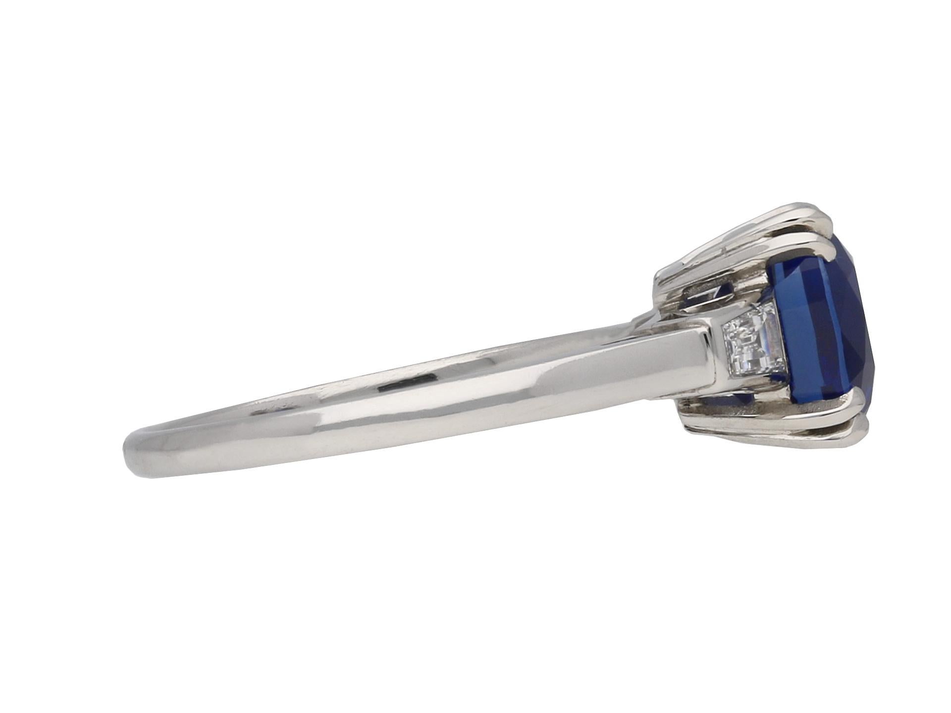 Royal Blue Kashmir sapphire and diamond ring. Set to centre with a single cushion shape old cut natural unenhanced Royal Blue Kashmir sapphire in an open back claw setting with an approximate weight of 2.35 carats, flanked by two tapered baguette