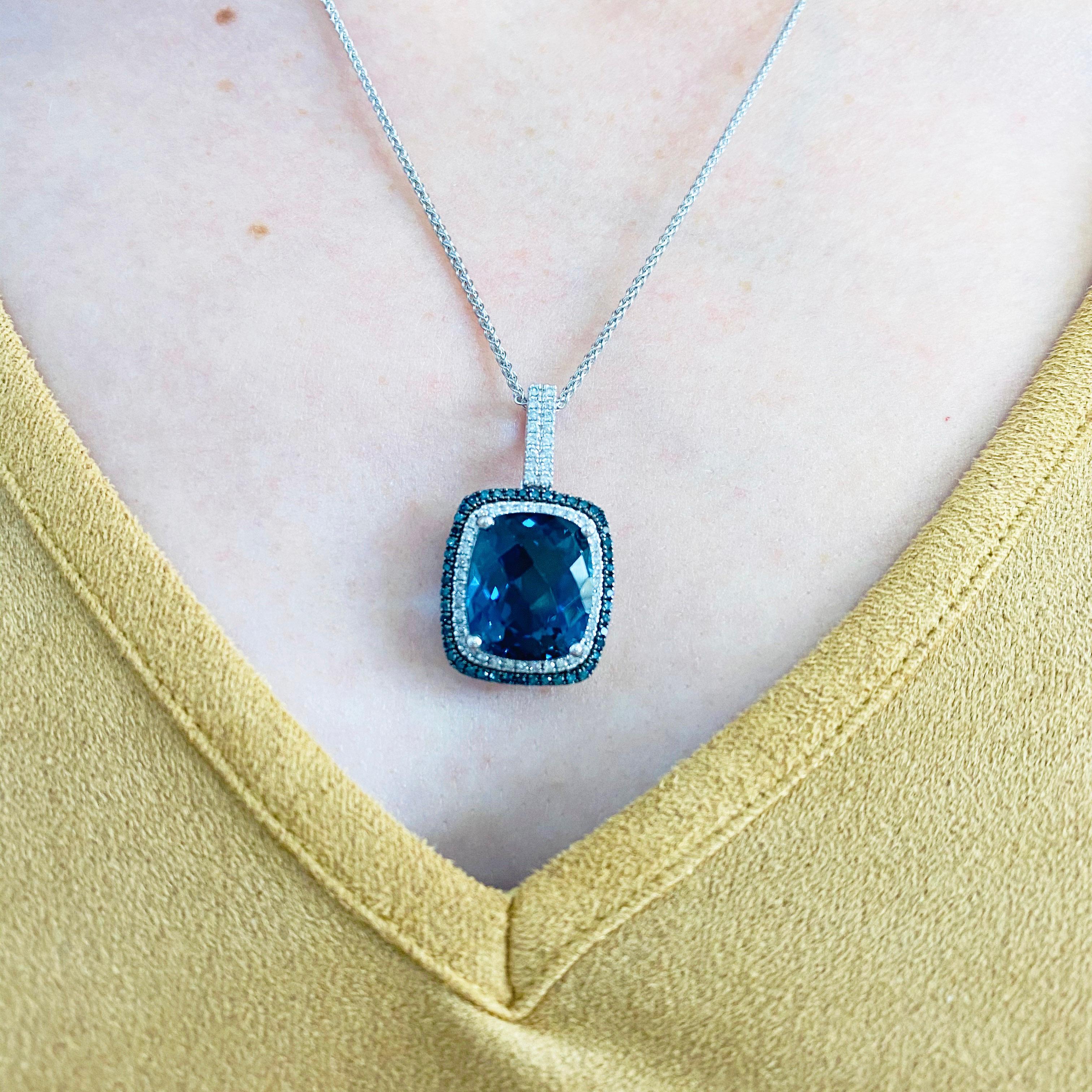 This royal blue colored  London blue topaz is set in polished 14k white gold and dripping with diamonds provides a look that is very modern yet classic! There are white diamonds around and blue diamonds around the white diamonds.  This necklace is