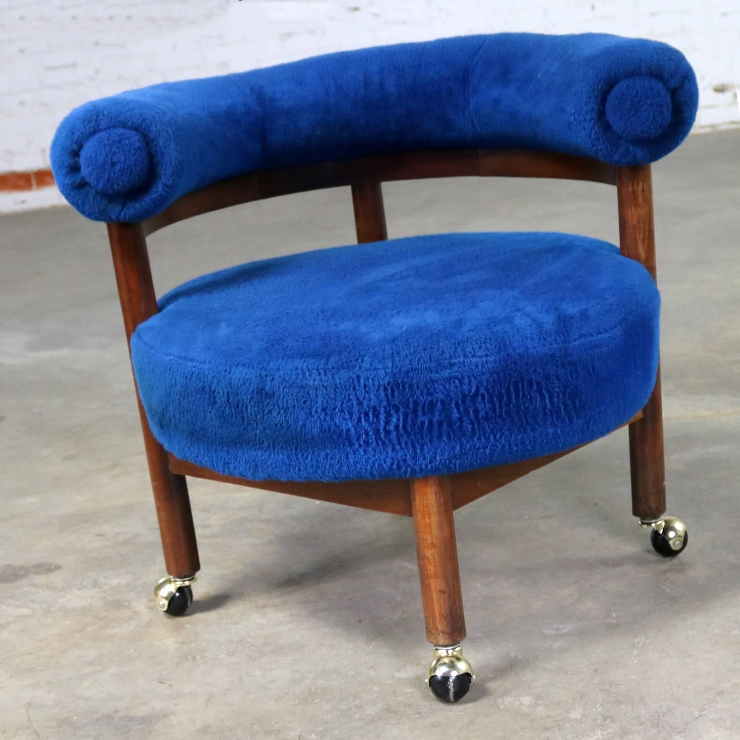 Fabulous Mid-Century Modern round upholstered corner lounge chair in royal blue fuzzy original upholstery with a bolster back on cylindrical wood legs with casters. This chair is in wonderful vintage condition apart from a cigarette burn on the seat