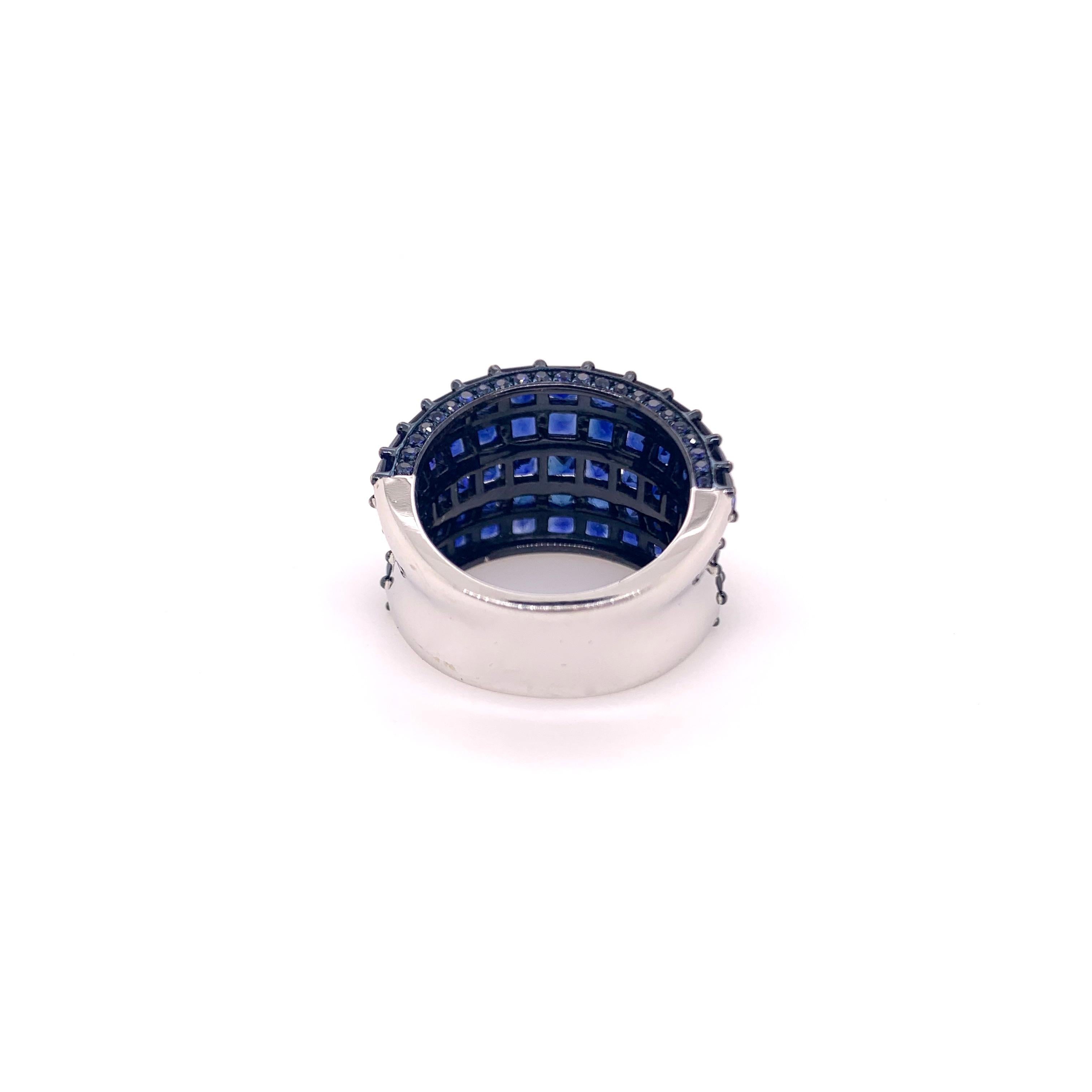 A stunning statement piece designed for casual and formal events! 18k White gold blue sapphire ring in a wide, cigar band style set with square and round cut sapphires.   The prongs are rhodium blue to give a more stunning, dramatic look! The