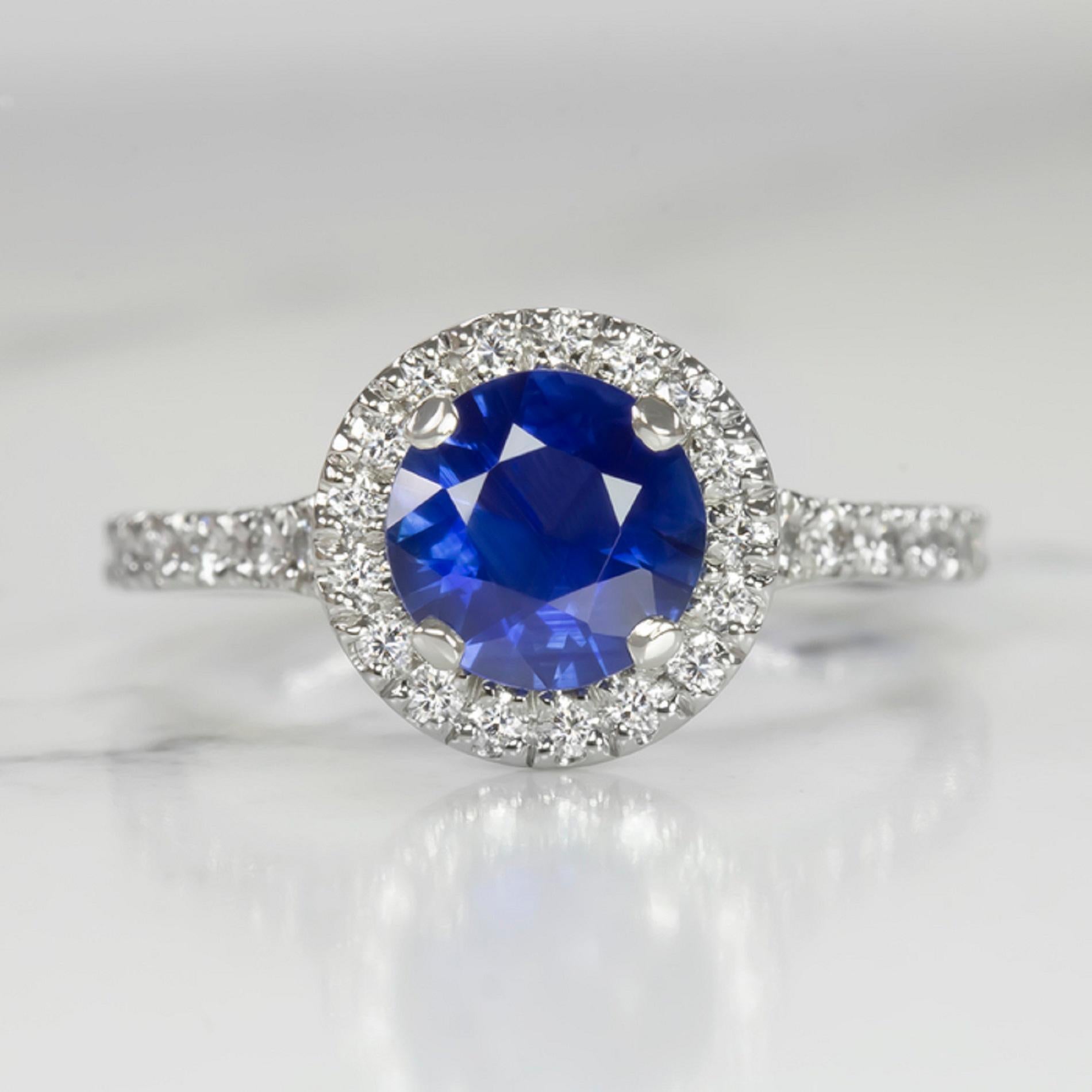 high quality sapphire and diamond ring has an eye catching, glamorous design featuring a royal blue sapphire in a luxurious, diamond encrusted platinum setting! The 1.14ct round cut sapphire center is a gorgeous royal blue color. It is a beautiful