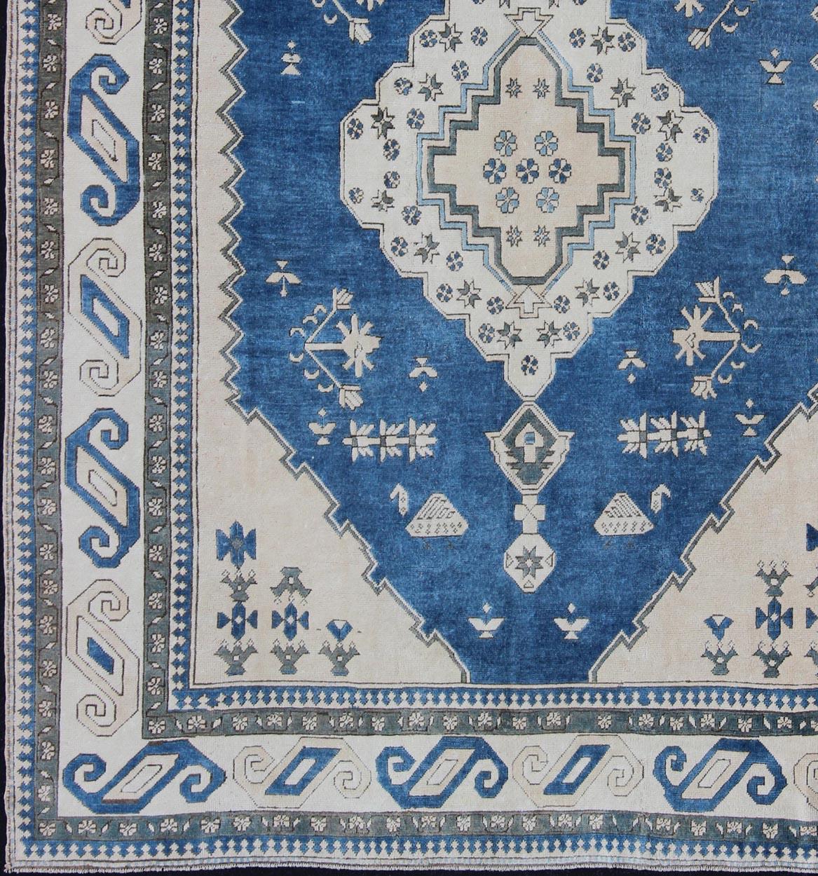 Vintage Oushak carpet with Geometric design, rug en-179331 country of origin / type: Turkey / Oushak, circa 1940.

This vintage Oushak carpet from third quarter of 20th century Turkey features a traditional medallion design rendered in tones of blue
