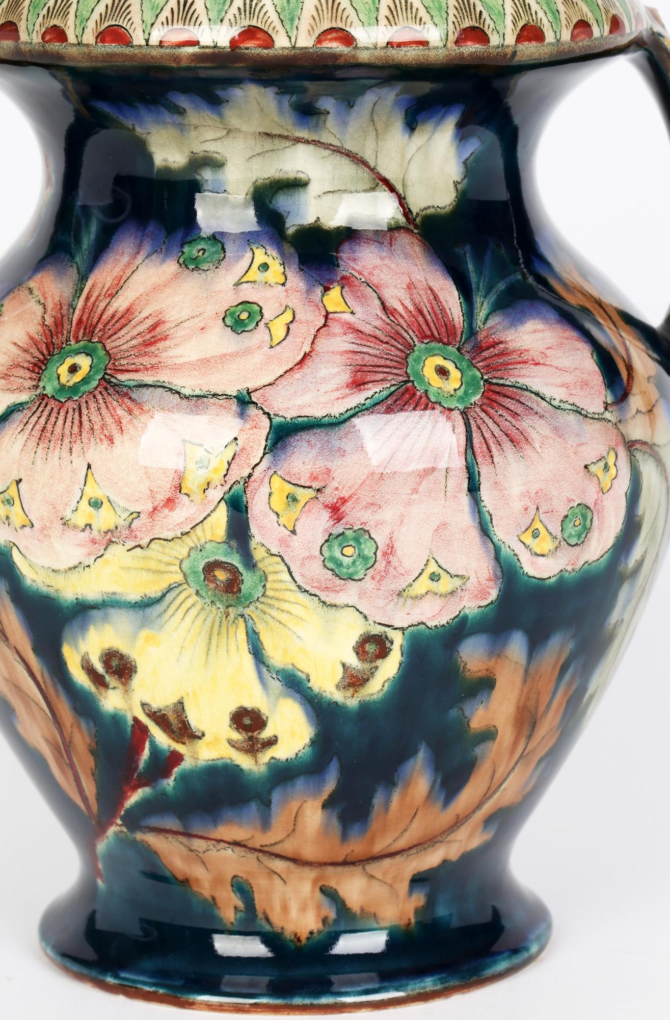 A large and stunning Art Nouveau German Royal Bonn twin handled vase painted with large floral designs in period style in the Old Dutch design and dating from circa 1890 and 1920. Made by Franz Anton Mehlem this impressive vase is stands on a narrow