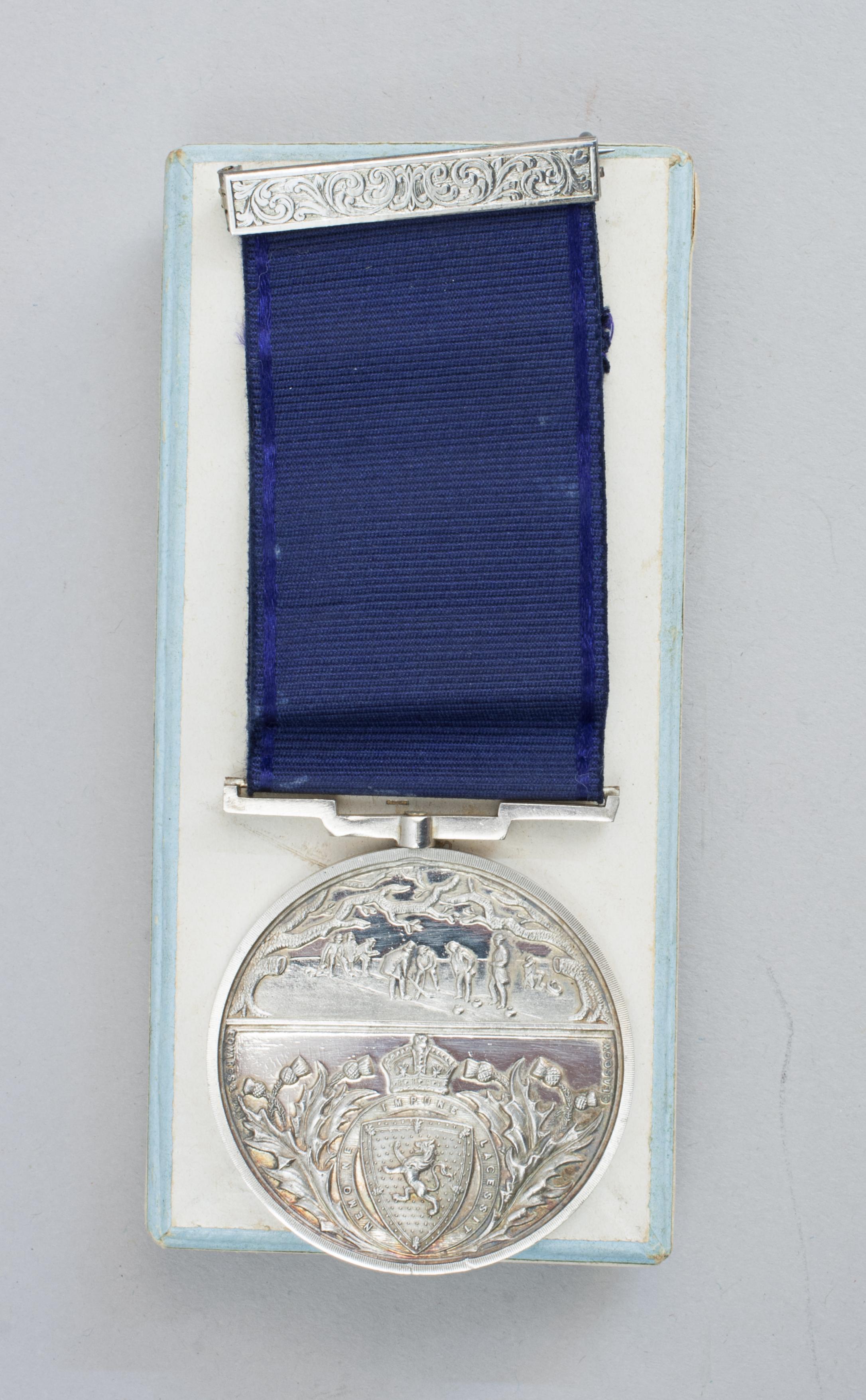 Edwardian Royal Caledonian Curling Club Silver Medal.
An unused, silver, district curling medal with blue ribbon and bar from the Royal Caledonian Curling Club. The curling medallion has no hallmarks or makers marks but comes in a Hamilton and