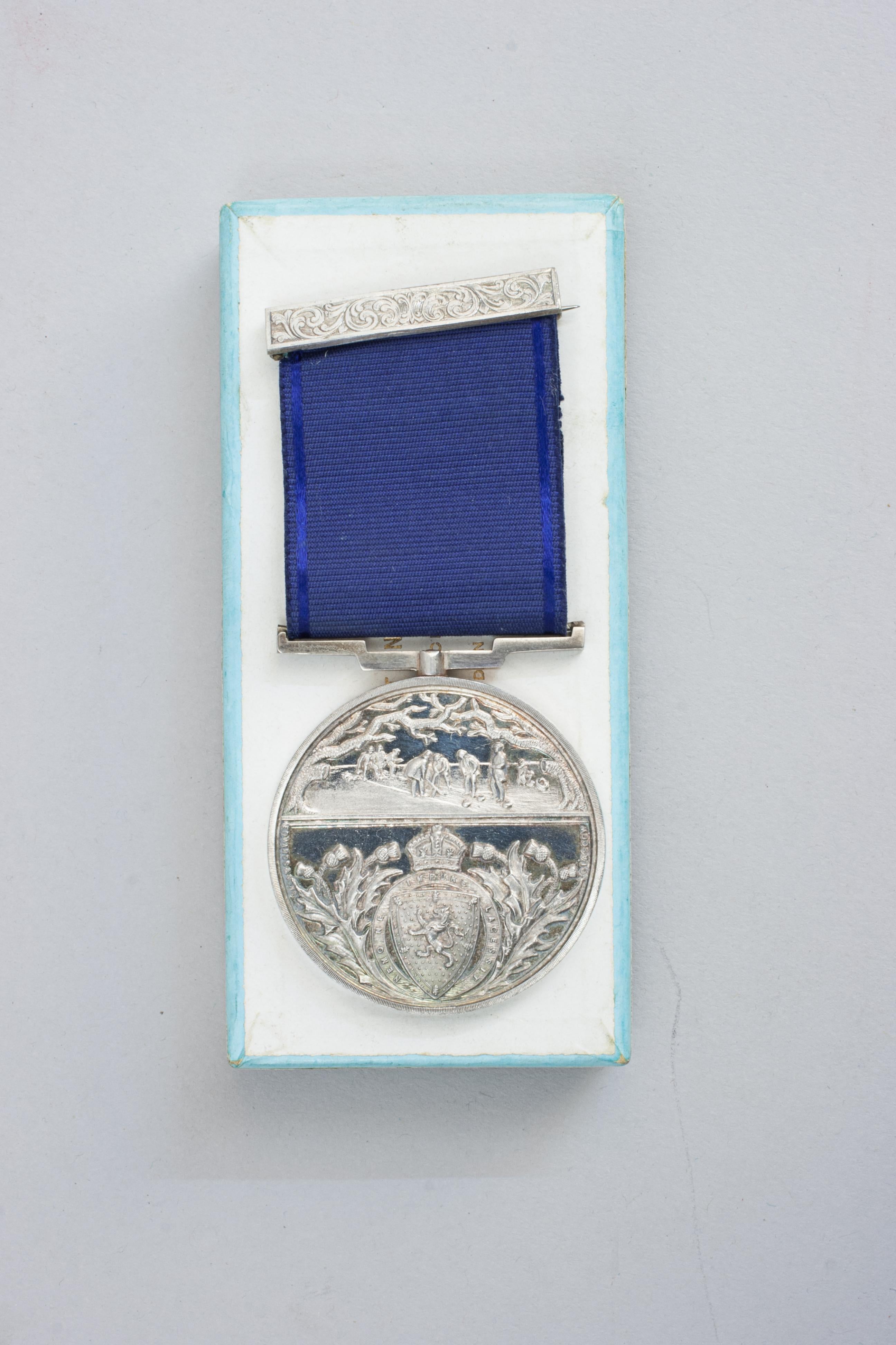Edwardian Royal Caledonian Curling Club Silver Medal.
An unused, silver, district curling medal with blue ribbon and bar from the Royal Caledonian Curling Club. The curling medallion has no hallmarks or makers marks but comes in a Hamilton and